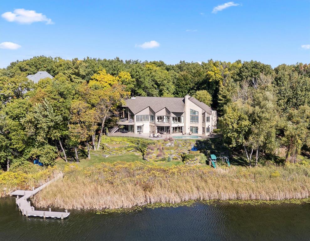 Welcome to an extraordinary blend of luxury, comfort, and functionality nestled within one of Bloomfield Township's most exclusive lakefront enclaves. This remarkable residence is set in the prestigious, gated Heron Bay community. Resting on the tranquil shores of All-Sports Upper Long Lake, this property offers more than just an address--it delivers a lifestyle defined by natural beauty, architectural grandeur, and seamless access to recreational enjoyment.Spanning approximately 8,200 square feet of pure ingenuity and elegance, this newly listed residence is designed for those with an eye for craftsmanship and an appreciation for detail. It boasts five well-proportioned bedrooms and eight thoughtfully appointed bathrooms (7 full baths and 1 half bath), all elegantly designed to cater to both daily living and large-scale entertaining. Set on meticulously maintained grounds and surrounded by mature trees, the home provides exceptionalprivacy without sacrificing its picturesque lake views and convenient access to all the community has to offer.

From the moment you arrive, the property's architectural sophistication is instantly apparent. The paver-lined circular motor court guides you to the stately fa??ade, flanked by two separate attached and heated two-plus-car garages. These are not just garagesthey are purpose-built havens for automotive enthusiasts, each equipped with its own vehicle charging station and expansive storage rooms, perfect for housing everything from seasonal items to weekend adventure gear.

Step inside, and you are welcomed into a grand foyer where soaring cathedral ceilings and rich hardwood floors establish an immediate tone of luxury. Floor-to-ceiling windows cascade with sunlight and frame stunning, uninterrupted views of the glistening lake beyond. Every window becomes a painting, every moment inside a mirror to the outdoors.

The home embraces single-level living with incredible intentionality, making it not only visually impressive but also functionally sound. At the heart of the main