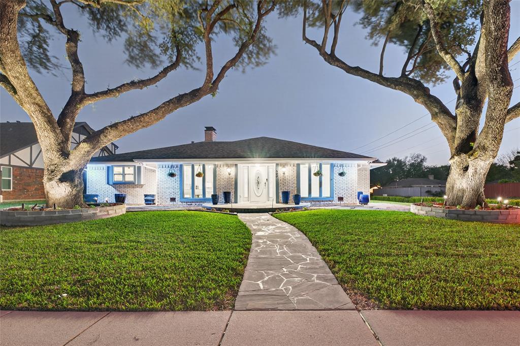 Winner of the 2024 City of Richardson Community Revitalization Award. This corner lot home has been thoughtfully renovated over nearly two decades with a level of care and craftsmanship that is rare to find. Every room has been updated with crown molding, custom cabinetry, granite countertops, and updated fixtures throughout. The exterior brick was hand-stained with concrete stain, not painted, so it will hold its color without maintenance. Natural flagstone hardscaping covers the front walkway, expanded front porch, and back patio with oversized stone seating areas shaded by mature trees. Nine irrigated garden beds surround the property. Inside, all common areas have granite tile flooring. The kitchen features cherry cabinetry, granite counters, and a Bosch induction cooktop. A custom home office with dual L-shaped granite desks and floor-to-ceiling storage sits near the front entry. The living room has a natural stone fireplace with a Blue Pearl granite hearth. All lighting is indirect bounce light designed to create a calm, even atmosphere throughout the home. The master suite includes a cedar-lined walk-in closet, soaking tub, and custom vanity. An additional bedroom and bath are built to aging-in-place standards with wide doors, grab bars, and a low-threshold shower. The climate-controlled garage has granite tile flooring, finished walls, and its own mini split HVAC. Systems include a 2021 Lennox Elite XC20 HVAC, 2020 Owens Corning roof, 2025 200-amp electrical panel, and 2025 seamless aluminum gutters with leaf guards. Hot tub, enclosed sunroom with flagstone floors, wired ethernet in 10 rooms, and a security system round out a property that has been maintained as well as it was built.