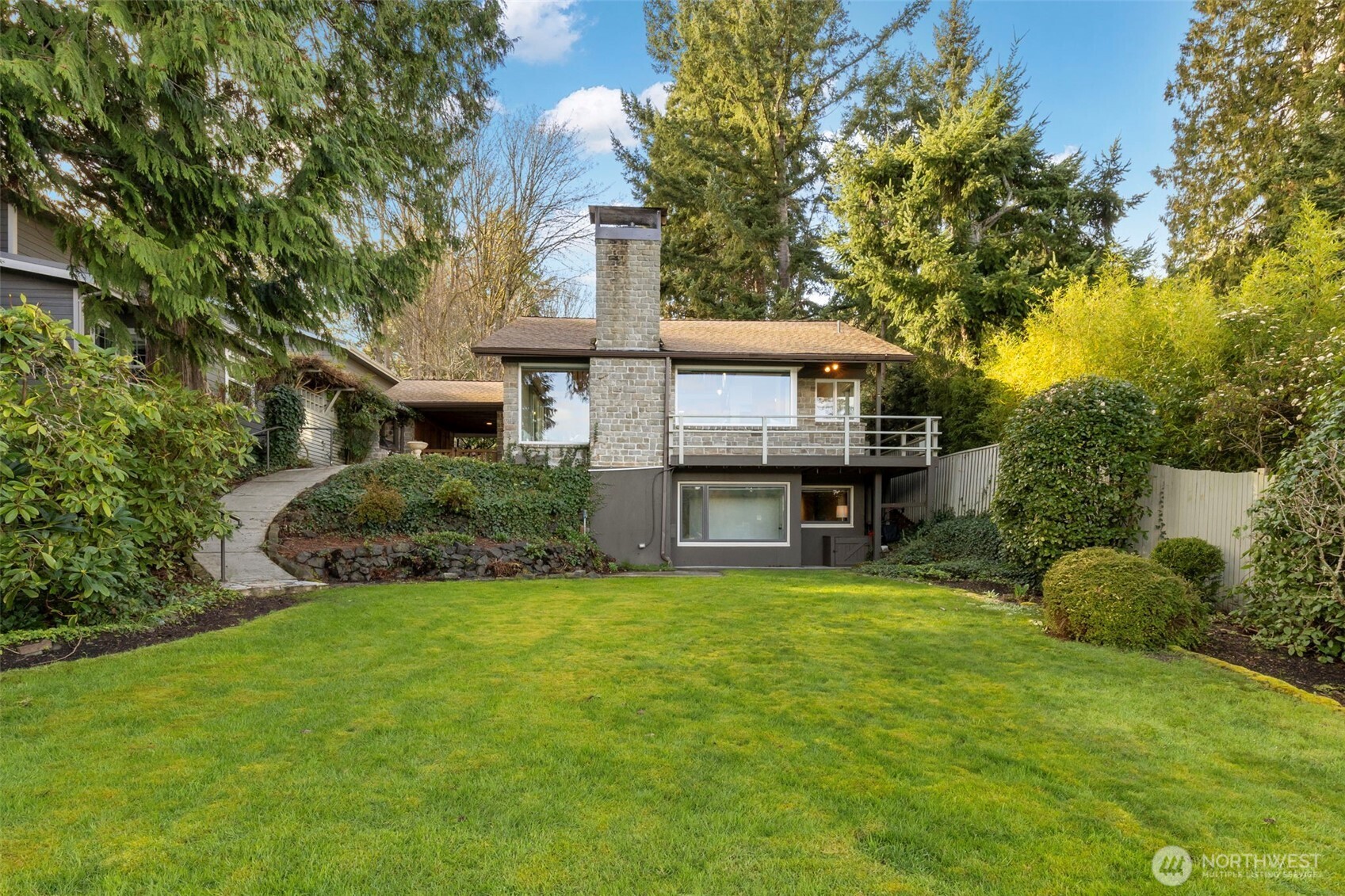 Straight out of a book, this stone cottage has 50ft of Agate Pass low-bank waterfront. Great natural light from the skylights and large picture windows with sound and mountain views. A balance of stone and warm natural wood accents throughout, including the vaulted ceiling. Main floor includes kitchen, great room, and primary bedroom. Upstairs is a smaller bedroom and separate loft area. Daylight basement includes a large second living room, guest bedroom, 3/4 bath, & utility room.  There are cozy fireplace inserts in the stone chimney on the main and lower levels. Deck has beautiful water views, perfect for your morning coffee while the side stone patio is set up with a built-in BBQ for peaceful evening dinners. Private level yard with mature landscaping gives the property privacy and a secret garden feeling. The multi-level deck and stairs lead down to the waterfront & bulkhead. Did you even know your secret wish was for a greenhouse on the water? Close to Kingston and Bainbridge ferries. So come live in your very own fairy tale just in time for summer!
