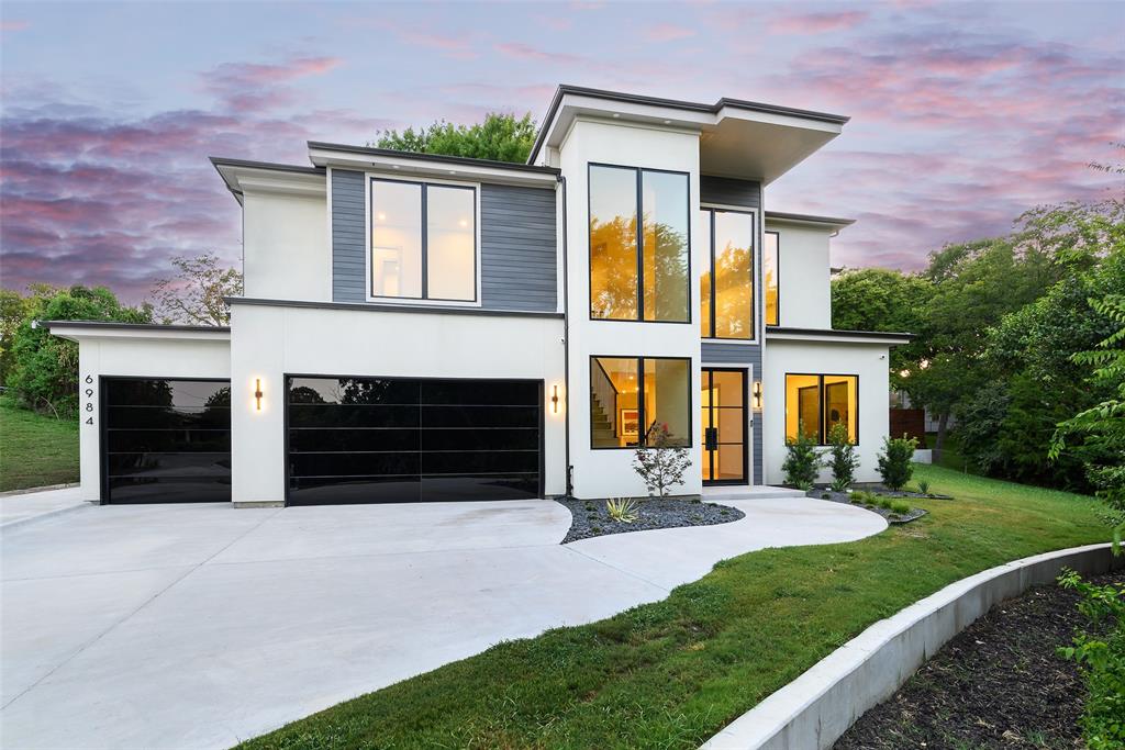 Nestled on a private, heavily treed .357-acre creek lot, this new construction home blends refined luxury with seamless indoor-outdoor living. With five bedrooms and elegant finishes throughout, it offers both comfort and sophistication.
Expansive windows and three sets of sliding doors flood the interiors with natural light and open to the outdoors. Steel entry and balcony doors, soundproofed windows, and white oak hardwood floors throughout set the tone for quality and style. Two upstairs balconies provide serene tree-top views, while the main level showcases a soaring limestone fireplace and a spacious great room.
The chef’s kitchen features a large island, Taj Mahal quartzite surfaces, and a butler’s pantry. The dining area includes dual custom wine coolers and a built-in wine storage, while the private upstairs suite offers a custom beverage fridge and balcony access.
Security and comfort are enhanced with an integrated system and exterior cameras. With its secluded setting and proximity to White Rock Lake, trails, and Lakewood Elementary, this property combines natural beauty with convenience.