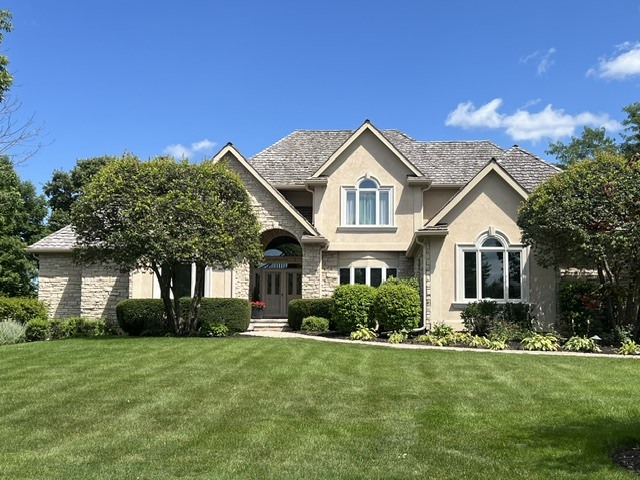 Experience luxury living at its finest in this exceptional stucco and stone residence, ideally situated on a quiet cul-de-sac within the prestigious gated community of Ivanhoe Estates.    Thoughtfully designed for both everyday living and grand entertaining, this impressive home features a sought-after first-floor primary suite, five additional bedrooms (6 bedrooms total ) five-and-a-half bathrooms, and three beautiful fireplaces. Spacious, light-filled living areas are complemented by timeless finishes and an outstanding floor plan.    The dramatic great room is the heart of the home, showcasing soaring ceilings, a stunning marble fireplace, and a sunken wet bar-creating the perfect space for gathering with family and friends while taking in the spectacular views.    The finished walkout lower level is an entertainer's dream, complete with a full bar, wine cellar and tasting room, expansive recreation area, stone fireplace, dedicated exercise room or bonus room, and direct access to the outdoor living spaces.    Step outside to an oversized Trex deck and stamped concrete patio overlooking the professionally landscaped backyard. Enjoy breathtaking lake views and panoramic vistas of the Prairie Course's first fairway at Ivanhoe Country Club. Whether you're enjoying your morning coffee, hosting guests, or relaxing at sunset, the setting is simply unforgettable-the views truly can't be beat.    With exceptional indoor and outdoor living spaces, remarkable entertaining amenities, and one of the most coveted golf course settings in Ivanhoe Estates, this extraordinary home offers a rare opportunity to experience luxury, elegance, and an unparalleled lifestyle.