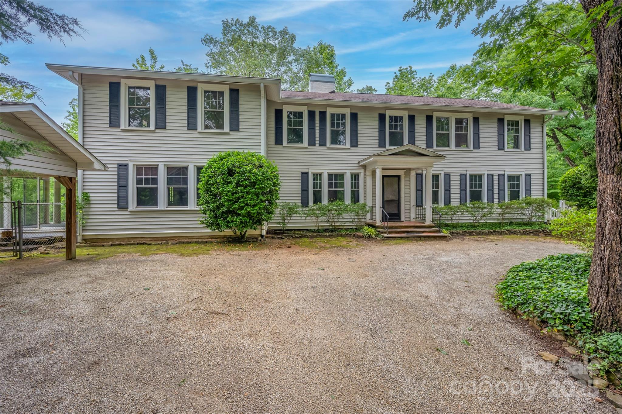 Priced below appraisal! Discover the potential of this 1930 classic, set in a peaceful setting just outside the heart of Tryon. With its generous scale, timeless architecture, and rare acreage, this home offers a unique opportunity to restore and reimagine a piece of history. Step inside and you’ll find spaces designed for gathering and entertaining: a welcoming parlor, an expansive great room with soaring ceilings and a stately fireplace, and a spacious dining room ideal for hosting. Original features like rich wood paneling, dentil molding, hardwood details, and four fireplaces throughout showcase the home’s enduring character.  The layout includes five bedrooms, a grand primary suite, a bright sunroom, and a large unfinished basement offering over 500 square feet for storage, hobbies, or work space. Outdoors, enjoy the peace of true privacy — over six wooded acres create a natural buffer from the outside world while remaining minutes from town and interstates. A multi-car carport with storage and a whole-house generator add convenience and peace of mind. This property is ready for its next chapter—whether you envision a full restoration, a modern transformation, or simply bringing back its 1930s charm. With space, privacy, and character rarely found in one package, it’s a chance to create something truly special in a coveted location.