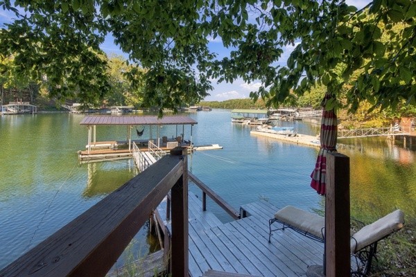 Experience lake living at its finest on beautiful Tims Ford Lake! This stunning renovated home offers 5 bedrooms, 3 full baths, and thoughtful updates throughout. Fresh paint and new flooring create a welcoming feel, while freshly painted cabinets, new hardware, and updated fixtures add a stylish touch. Two bathrooms feature new tile, vanities, and fixtures. A new roof and new asphalt parking pad round out the improvements. Step onto the gorgeous covered back porch, where a stone gas fireplace sets the scene for morning coffee, relaxed evenings, and gathering with friends after a day on the water. Your lake adventures begin at the boat dock, extended by 10 ft and upgraded with all-new decking and a new gangway. Complete with a boat lift and jet ski port, this property is ready for days spent cruising, splashing, and soaking up the Tims Ford lifestyle. Whether you're dreaming of a full-time lake retreat or a weekend escape, this beautifully refreshed home is ready to welcome you! Enjoy picturesque lake views from the stunning back deck and your master suite. Take a short boat ride to one of our 3 marinas and enjoy dinner on the water.