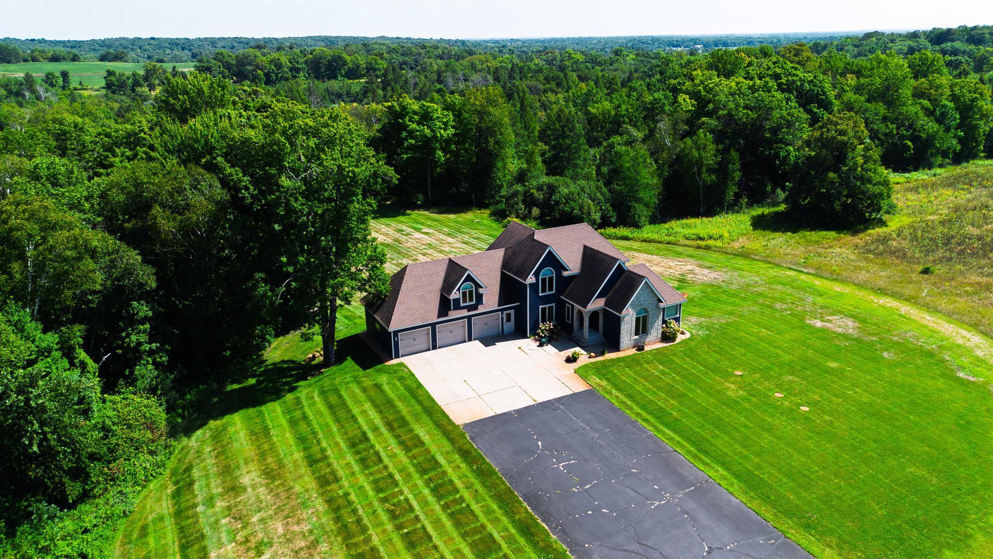 Tucked away in a peaceful country setting at the end of a shared private driveway, this remarkable 4-bedroom, 4-bath home offers 4,301 square feet of beautifully finished living space on 30 acres of diverse countryside. Surrounded by hundreds of acres of farmland and woods, this property offers an exceptional sense of privacy and seclusion while remaining conveniently accessible to the amenities of town. With St. Cloud approximately 20 minutes away, Sartell just 15 minutes, and Interstate 94 about 15 minutes, you can enjoy the best of both worlds - seclusion on a beautiful private estate when you want it and convenient access when you need it.From the moment you enter, the quality and character of this home are evident. An impressive custom wood staircase welcomes you, immediately setting the tone for the beautifully crafted woodwork throughout the rest of the home. The spacious kitchen provides an inviting gathering place, complemented by a formal dining room leading out to a new deck overlooking the calming landscape for larger occasions. The living room features a gas fireplace, creating a warm and comfortable space to come together and relax.The main-level primary suite offers a true retreat, complete with a whirlpool tub, tiled walk-in shower with glass enclosure, heated towel bar, and a television integrated into the bathroom mirror. Upstairs, the two bedrooms are connected by a Jack-and-Jill bath, while the spacious bonus room above the heated three-car garage offers the perfect spot for games, hobbies, movie nights, or additional space.The finished walkout basement adds valuable living space with an additional bedroom, open living area, bathroom, laundry room, and plenty of storage. With direct access to the outdoors, this level offers flexibility for guests, recreation, hobbies, or everyday living. Outside is where this property truly sets itself apart. The 30 acres offer a diverse combination of wooded terrain, gentle slopes, lowland pockets, and a pond, creating an attractive and functional landscape for both recreation and an abundance of wildlife. The pockets of the lowland areas are accessible by foot and provide excellent natural cover and bedding habitat. Approximately 1.5 acres that were previously used for food plots are now established in native grasses, adding another valuable component to the property's wildlife habitat. Whether you're an avid hunter, outdoor enthusiast, hobbyist, or simply looking for a private place to call home, this acreage offers tremendous potential in a convenient location. Recent updates include the new deck, windows, doors, lighting, and James Hardie low-maintenance siding installed in 2020. The property also includes a large shop in the backyard, providing abundant room for equipment, vehicles, projects, storage, or recreational toys.With exceptional craftsmanship, updates, generous living space, a heated three-car garage, substantial shop, geothermal efficiency, and 30 acres of diverse and secluded land, this is far more than a home - it is a place to enjoy the land, the wildlife, and the seclusion that comes with owning a truly special private estate.