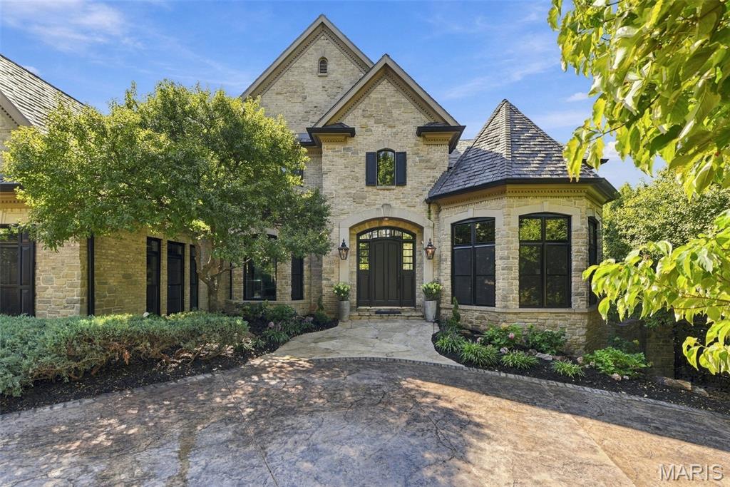 Rare opportunity to own an exceptional home on a private, gated street in Ladue Schools. Magnificent estate is located on one acre with over 8200 square feet of living space, lush landscaping, gunite pool and spa, and a one-of-a-kind pool house. This home is not to be missed! New features include a stunning, upgraded composite cedar shake roof, new windows and flooring throughout, kitchen granite, and paint. Designed for entertaining, the first floor features a sweeping staircase, dining room with bay window and tray ceiling, library with built in bookcases, powder room, large kitchen, stainless steel appliances, walk-in pantry, hearth room, stone fireplace ,breakfast room with stone surround and walkout to large deck, laundry room, half bath, spacious great room with fireplace, dramatic floor to ceiling windows overlooking the pool and pool house, and the primary bedroom suite. The large primary bedroom with a wall of windows includes two walk in closets, bath with two vanities, separate shower and brand new stand alone jetted tub. Upstairs includes three generous sized bedrooms, one with a private bath, one with a Juliette balcony that shares a Jack and Jill bath with the third bedroom. The flow of entertaining continues in the lower level with the family room, fireplace, game room, bar, walkout to pool and pool house. Fifth bedroom with bath and steam shower, play area or exercise room, and ample storage complete the lower level. The "Colorado Style" pool house is extra special with doors that open to the pool deck, living room with floor to ceiling stone fireplace, kitchen, laundry room, bedroom, and back deck. The backyard is an oasis for resort style living. Other amenities include a whole house generator, sprinkler system, security system, landscape lighting, gas lights, and "Smart Home" Crestron System. There is a three car side entry garage with two lifts for the car enthusiast and a stamped concrete circle driveway. Walk to Spoede Elementary School.