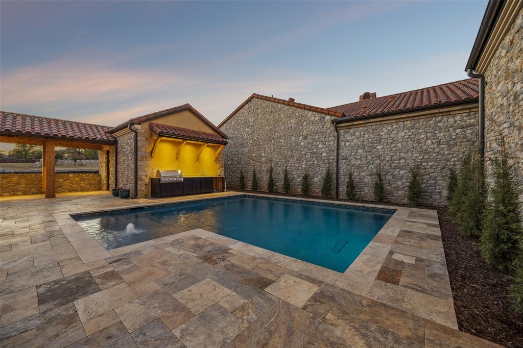 Built by the esteemed David Ford, LLC, this luxurious Mediterranean-inspired estate blends timeless design with refined modern living. A dramatic entry opens to a stunning courtyard centered around a sparkling pool with a water feature. Designed for entertaining on a grand scale, the outdoor living area offers a fully equipped summer kitchen and a private casita. The courtyard comfortably hosts many guests, creating a true resort-style setting. The casita offers exceptional flexibility with a living area, kitchenette with bar, and full bath, deal for guests or extended stays. Two of the four spacious bedroom suites open directly to the courtyard, enhancing the seamless indoor-outdoor flow. The main living level is accessed via staircase from the arcade or private elevator from the garage. Inside, expansive open-concept living spaces are designed for both elegant entertaining and everyday comfort. The chef’s kitchen features floor-to-ceiling cabinetry on three sides, a central island, and Taj Mahal quartzite countertops. Premium appliances include a 48” Wolf cooktop, Wolf double ovens, Sub-Zero refrigerator and freezer, Bosch dishwasher, and a coffee bar. The grand living area is anchored by a cast stone fireplace and flows into a paneled study, powder bath, and a sophisticated wine room with 132-bottle cooler, wet bar, and additional storage. The formal dining room offers flexibility as an additional living space. The primary suite is a private retreat with a sloped cedar ceiling, patio access, and double doors opening toward the pool courtyard. The spa-like bath features a marble-walled glass shower, soaking tub, and dual quartzite vanities. The oversized custom closet includes two levels of hanging space on three walls, a built-in dresser, and stackable laundry. Throughout the home, Knotty Alder wood doors and trim are paired with soft, warm tones for a cohesive luxury feel. Students attend International Baccalaureate Westlake Academy.