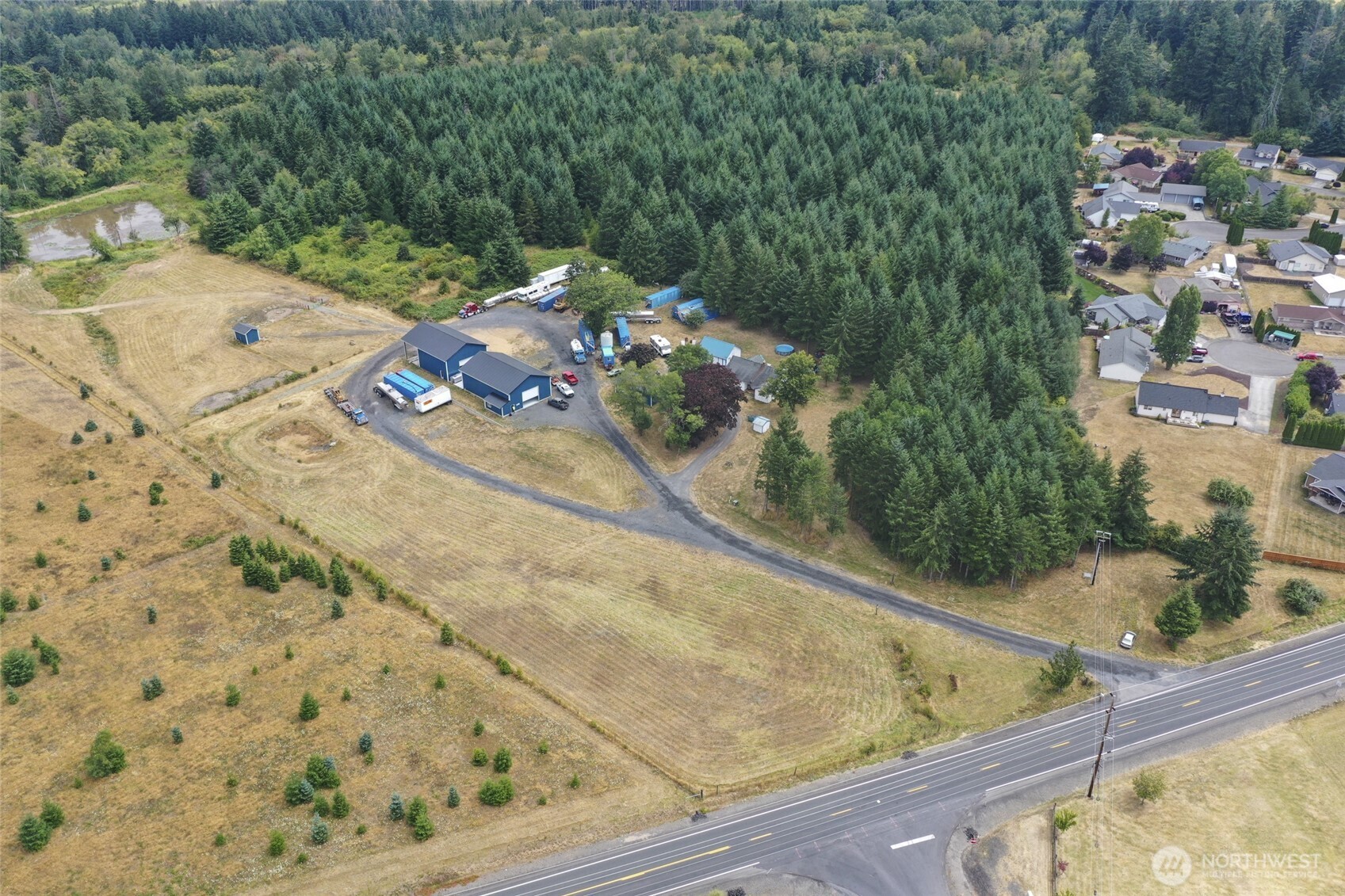 Rare 12.58-acre commercial/industrial property in Napavine with Hwy 603 frontage, railroad adjacency, residential rental income and agricultural use. Two approximately 2,400 sq. ft. metal industrial buildings with concrete floors were developed and permitted for chemical manufacturing/processing, with substantial investment in engineering, commercial water, electrical systems and related infrastructure. Extensive permit and supporting documentation is available. One building includes approximately 300 sq. ft. of office space.A commercial well with well house and storage tank serves the property, along with a large gravel drive and turnaround area. Railroad frontage may allow a future rail spur, subject to railroad and governmental approval.Additional features include fenced acreage suitable for cattle grazing, a pond, two RV hookups and two rented homes. The approximately 1,704 sq. ft. older home rents for $1,000/month and needs repairs; the approximately 1,000 sq. ft. newer home is in excellent condition and rents for $1,500/month. RR-5 zoning may offer future division or additional uses, subject to Lewis County approval and buyer verification. A versatile site for manufacturing, agricultural business, storage, distribution or owner-user operations.- Some photos are virtually staged