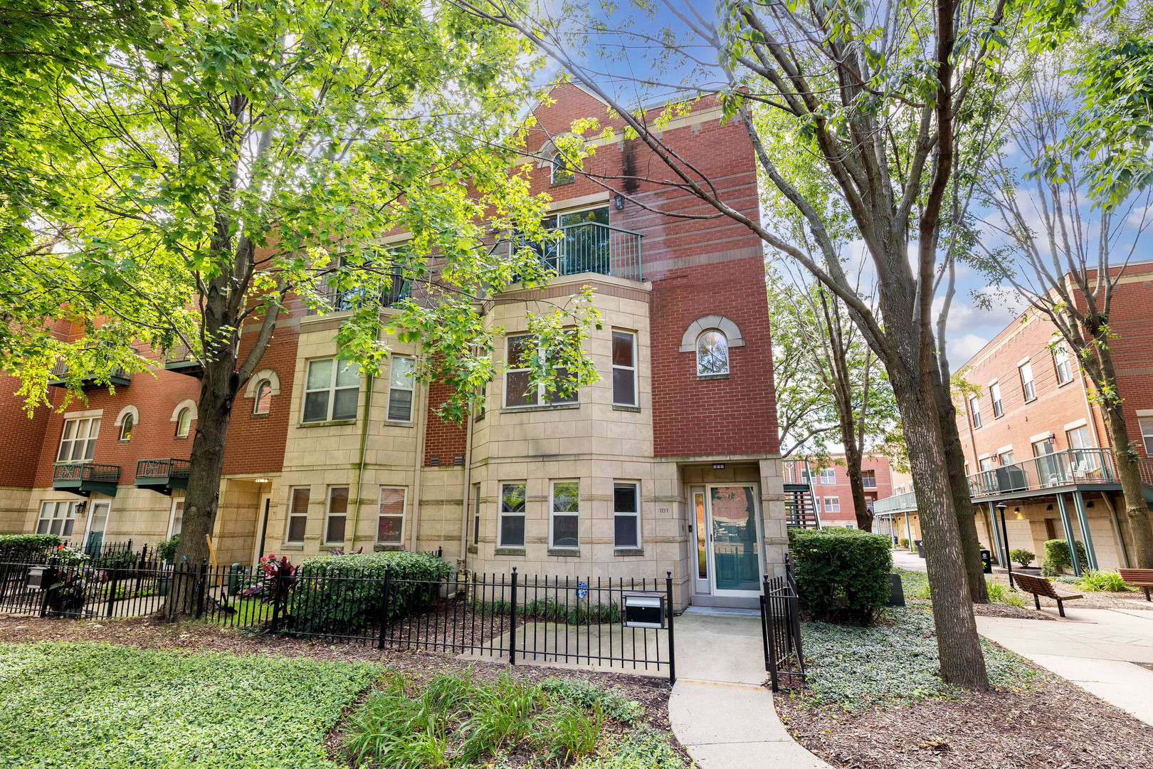 This expansive three-story end-unit townhome offers the perfect blend of space, comfort, and style-all set within a serene, park-like setting that feels suburban yet remains close to everything. As you approach the home, you are greeted with your own gated landscaped patio that lead you to your home.  The highlights are its own private entrance and an attached two-car garage, 4 bedrooms, 3 full bathrooms, and three inviting outdoor spaces. Step into the private foyer and discover a versatile first-floor room with its own full bathroom-ideal as a guest suite, home office, or den. The second floor opens into a sun-drenched great room, where curved windows, a cozy fireplace, and an airy layout create a warm, welcoming space. The spacious kitchen offers ample cabinetry, granite countertops, stainless steel appliances, and room for a breakfast table. From here, step out onto a generous balcony-perfect for indoor/outdoor entertaining. Upstairs, a skylight brightens the staircase and hallway, leading to three more bedrooms, two full baths, and a convenient laundry room. The highlight is the oversized primary suite, complete with vaulted ceilings, double closets, a large private ensuite, and a private balcony with stunning views of the Chicago skyline-ideal for morning coffee or unwinding at sunset. Just a short walk to the lakefront, Metra, Hyde Park shops and restaurants, and the University of Chicago, this home truly has it all. Welcome home.