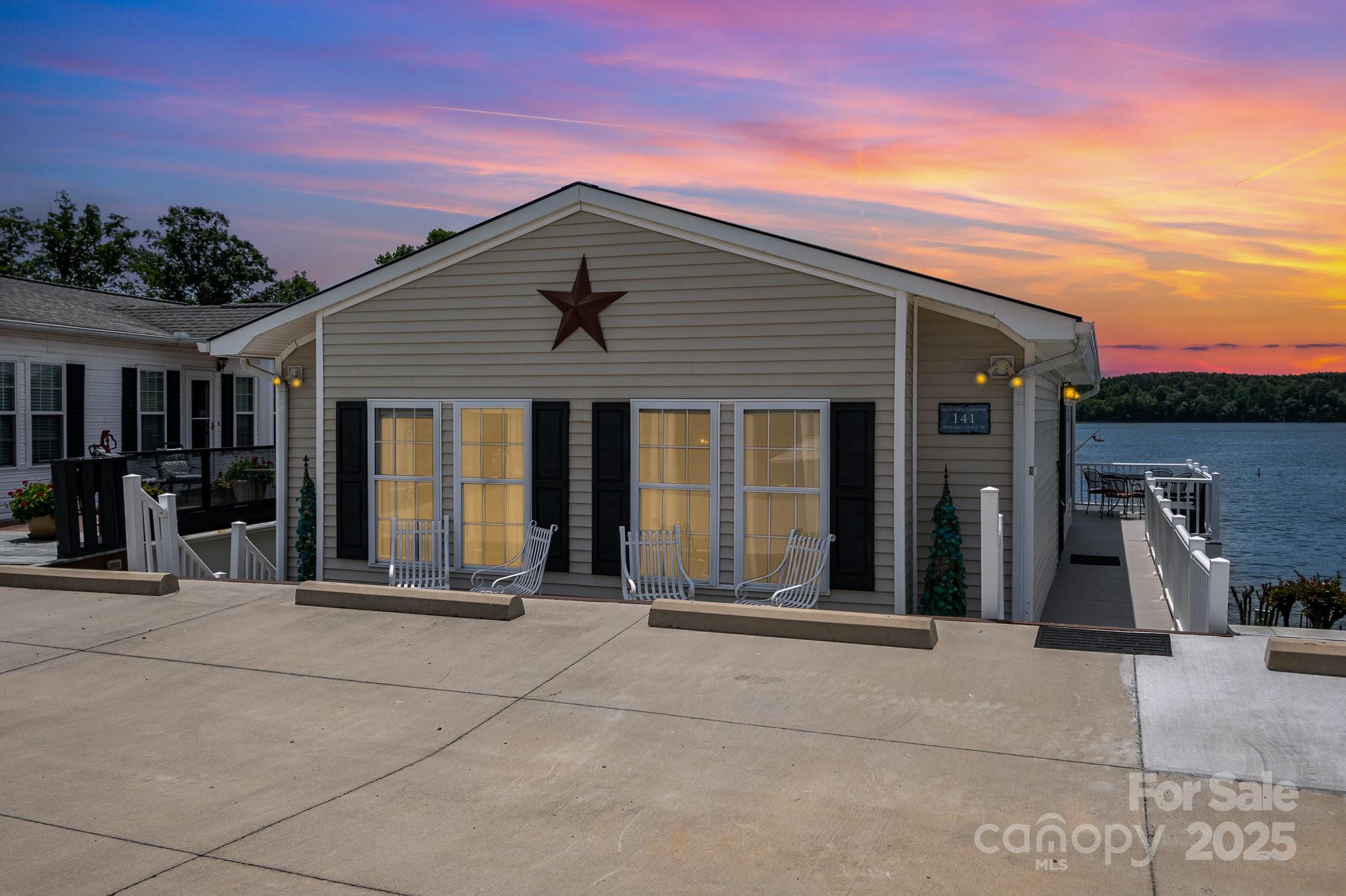 Enjoy unobstructed lake views from this beautiful 2-bedroom, 1.5-bath waterfront home located in the gated community of Badin Shores Resort. Whether you're relaxing on the spacious covered porch (added in 2020) or enjoying the scenery from the open-concept living area, the lake is always the backdrop. The updated kitchen features solid surface countertops and stainless steel appliances. Incredible storage space is located downstairs off the covered patio. Step outside to direct access to the over 1-mile community waterfront boardwalk—perfect for a peaceful walk with stunning views. Resort amenities include a swimming pool, putt putt, basketball courts, sandy beach and lake swim area, fishing pier, stocked catch-and-release pond, clubhouse, boat ramp, on-site restaurant, and more. Experience the best of lake life in this active, amenity-rich waterfront community!
