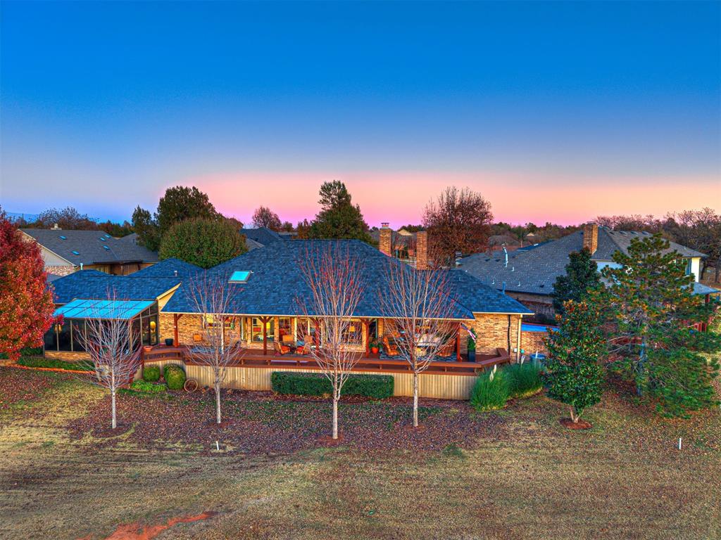 Welcome to a truly exceptional residence within the gated East Oak Place enclave of Oak Tree Country Club, one of Edmond’s premiere golf course communities. This home offers a rare blend of elegance, space, and lifestyle — a dream retreat for those who value luxury living and entertaining. Inside, you’ll find a flexible floor plan with an upstairs that can function as either a bonus room or a bedroom. Both the bonus room and the study have en suite bathrooms, in addition to the other two bedrooms having en suite full baths. The primary suite is a show-stopper: a large bedroom with a cozy fireplace, plus an oversized spa-style bath, and direct views of the private pool. Entertaining will feel effortless with two separate living areas and a massive chef-worthy kitchen that opens to the home’s heart. The kitchen has everything a culinary enthusiast could want — ample counter and cabinet space, a layout designed for cooking and entertaining alike, and a flow that connects with the living and dining zones. Step outside to the huge back deck and you’re greeted with breathtaking views of the manicured golf course, serene pond, and incredible Oklahoma sunsets — a setting rarely rivaled in Edmond. The private pool adds another dimension of resort-style living, creating a peaceful oasis right in your backyard. Positioned inside a guarded, gated community known for its championship golf course, country club amenities, and serene setting, this home offers not just a place to live — but a lifestyle many aspire to. It stands out as one of the most special homes in Oak Tree, especially for anyone drawn to golf, privacy, and elevated living. The HOA fees cover yard maintenance and flower bed care plus tree pruning. The house is painted every 5 years and gutters cleaned twice a year.