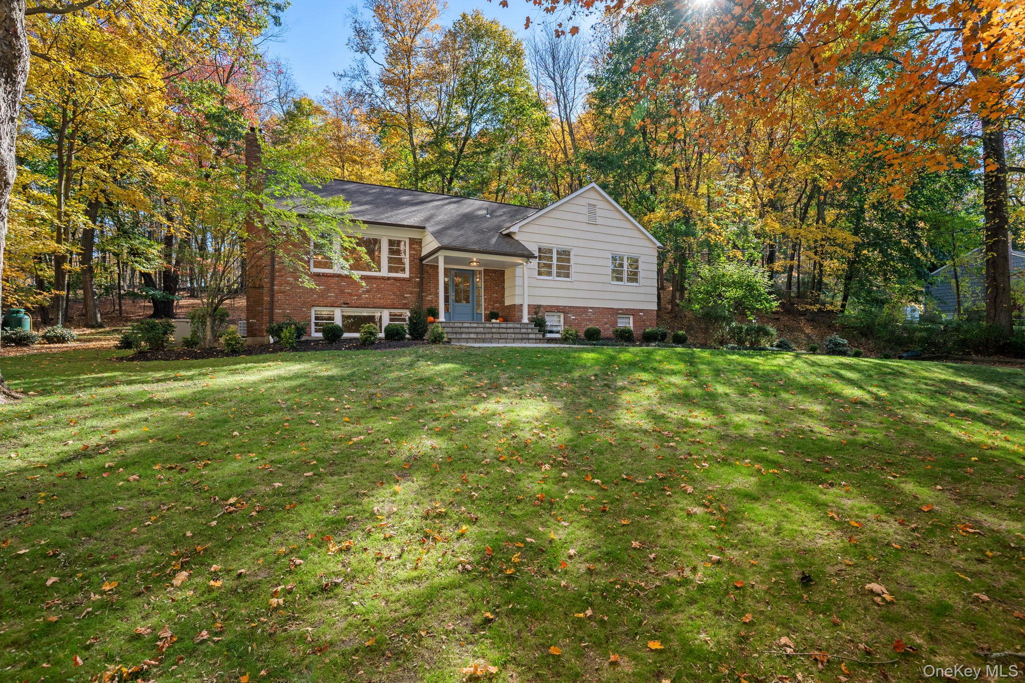 Discover the perfect balance of modern design and peaceful living at 341 Millwood Road. Set on nearly 2 acres of wooded privacy within the Chappaqua School District, this completely renovated 4-bedroom, 2.5-bath Raised Ranch has been transformed from top to bottom. Every detail shines - from new flooring, doors, moldings, lighting, and baths to a stunning eat-in kitchen with GE Cafe WiFi-connected stainless-steel appliances, quartz counters, marble backsplash and a picture window overlooking the scenic backyard. The lower level features a custom mudroom, laundry center with new washer and dryer, family room with wood-burning fireplace, a large guest room , cedar closet and half bath. Outdoors, enjoy a turnaround driveway, new landscaping, a large deck, and a tiered yard ideal for a fire pit and playset. With new HVAC, above-ground oil tank, and full-house generator, this move-in-ready home blends modern luxury with timeless tranquility.