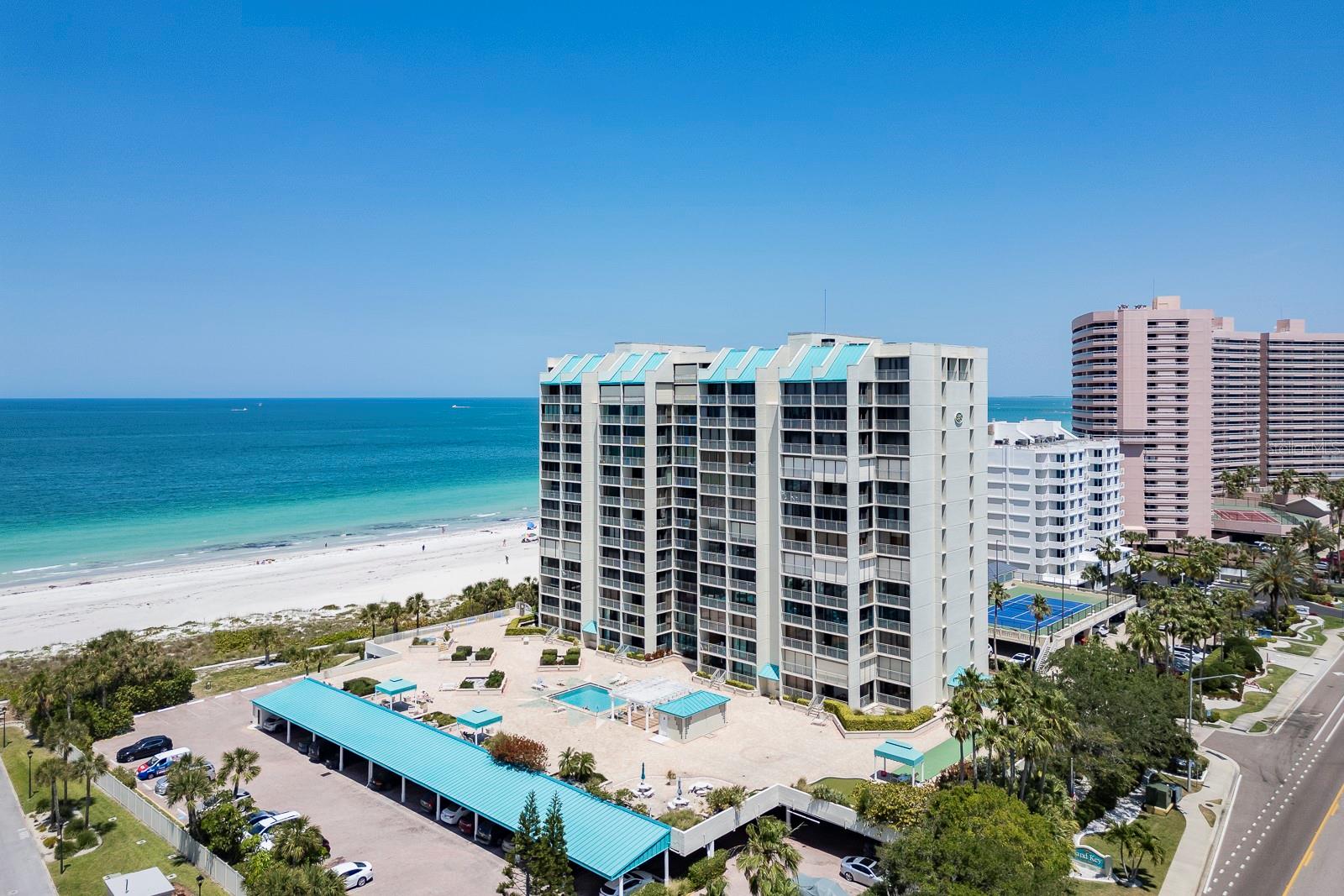 Commanding the 12th floor just below the penthouse at the prestigious Sand Key Club, this impeccably renovated Gulf-front residence delivers a rare blend of sophistication, privacy, and breathtaking, unobstructed water views. With coveted southern exposure, this 2-bedroom, 2-bath coastal retreat captures both radiant sunrises over the Intracoastal and dramatic sunsets melting into the Gulf of Mexico—an everyday backdrop that never gets old.  Inside, refined coastal elegance meets modern design in a fully furnished, turnkey residence where every detail has been thoughtfully curated. An open-concept layout anchored by travertine and designer tile flooring flows seamlessly to floor-to-ceiling glass and a versatile enclosed balcony/sunroom, creating a true indoor-outdoor living experience high above the shoreline. The chef-inspired kitchen features sleek shaker cabinetry, polished granite, premium stainless appliances, an extended serving bar, and effortless connection to the expansive living and dining spaces, complete with a custom fireplace and elevated finishes throughout.  This condo boasts a full size laundry / utility room for extra storage and provide for everyday ease.  Residents enjoy resort-caliber amenities including direct access to Sand Key’s powder-soft beaches, a Gulf-front heated pool and spa, cabanas, fitness center, sauna, club room, and 24-hour gated security with lobby attendant. Ideally located just minutes from fine dining, boutique shopping, Clearwater Beach, and two international airports, this is an exceptional opportunity to own a premier beachfront residence in one of the Gulf Coast’s most sought-after communities.