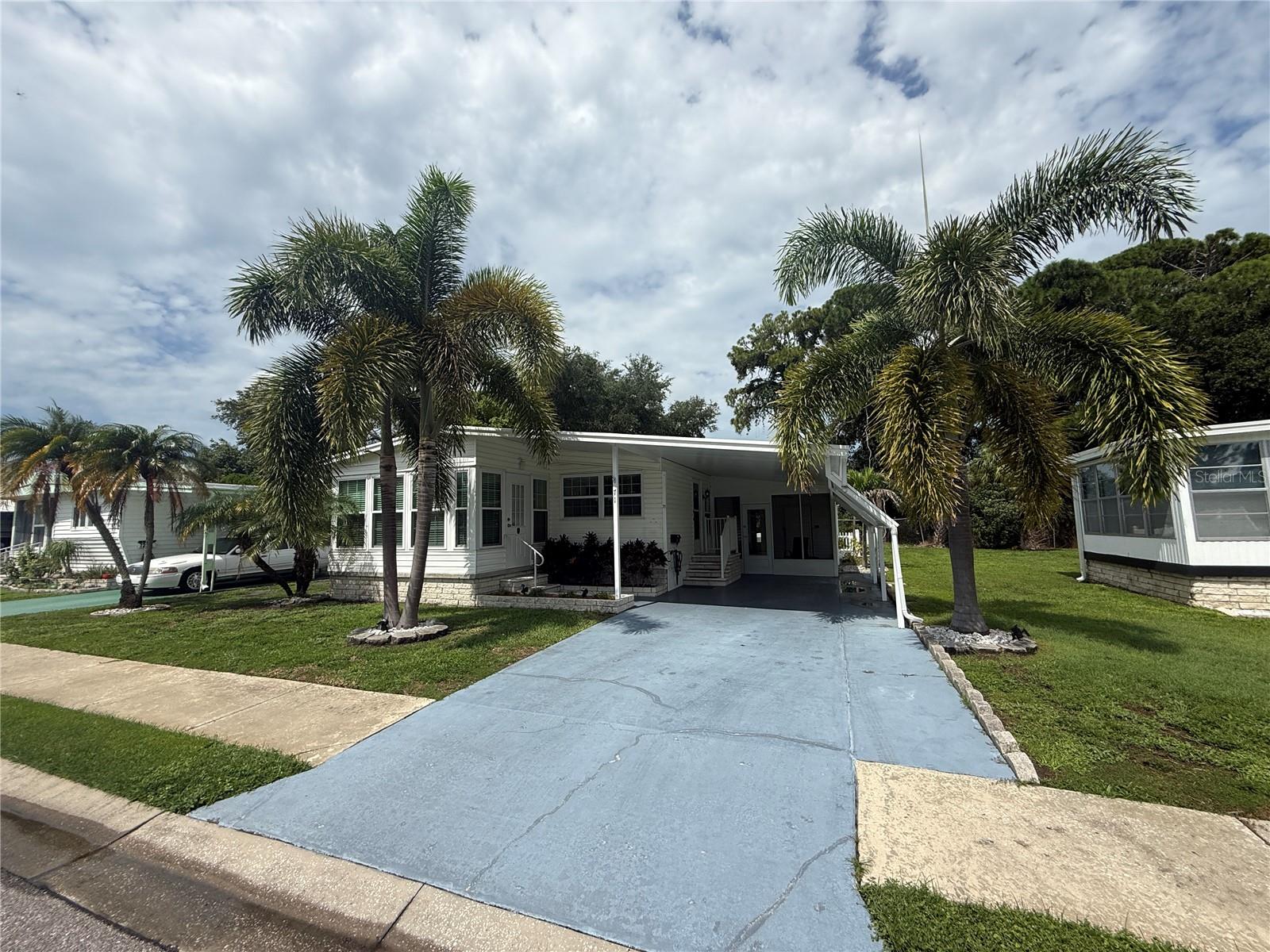 Affordable, light-filled 2BR/1.5BA + bonus room in resident-owned Greenbriar Village, a friendly 55+ community in the heart of Pinellas Park! This home is filled with natural light throughout and features a nicely remodeled kitchen with solid surface countertops in an open kitchen-dining combo, perfect for everyday living and entertaining.  Crown molding adds a polished, upscale touch throughout the main living areas. The large living room flows into a versatile bonus room off the main living space, ideal for a home office, den, craft room, or guest space.The primary bedroom is generously sized with a full en-suite bath and offers ample closet space, along with plenty of storage throughout the rest of the home. A convenient half bath doubles as a laundry closet with a stackable washer/dryer combo tucked neatly inside.Outdoor living is a real highlight here. Enjoy a screened-in patio perfect for morning coffee or year-round relaxing, plus a large workshop shed ideal for projects, hobbies, or extra storage. A covered breezeway leads to the backyard, which is fully fenced — a great feature for pet owners — and includes three additional storage sheds, offering more storage than most comparable homes in the area.As a resident-owned community, Greenbriar Village gives homeowners real ownership rather than simply renting a lot, along with a low $230/month maintenance fee that covers water, sewer, garbage, a heated community pool, shuffleboard courts, and clubhouse access — an incredible value that’s hard to match anywhere in Pinellas County.The location is unbeatable, with quick access to shopping, dining, parks, golf, and the Gulf beaches. Nearby favorites include Sawgrass Lake Park, Mainlands Golf Club, the Lake Walsingham trail, local breweries, and a great local food scene, all just minutes away, with downtown St. Petersburg and Clearwater an easy drive in either direction.This move-in-ready home combines thoughtful updates, exceptional storage, and outdoor living space you won’t find in most comparable listings — all within a welcoming, established community. Schedule your private showing today!