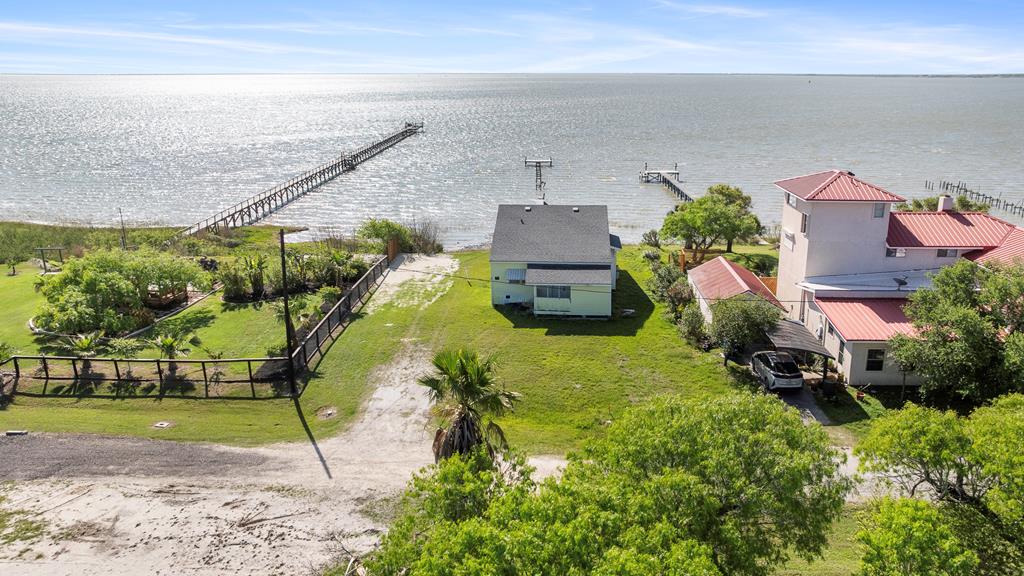 Charming 1930s waterfront home with stunning Copano Bay Views!  Step back in time while enjoying modern comforts in this lovely 1930s home.  This 2 bedroom, 2 bathroom retreat offers breathtaking views of Copano Bay with a wall of windows across the back, bringing the outdoors in.  Inside, you will find original shiplap walls, rich hardwood flooring, and a cozy, welcoming ambiance.  The spacious living area flows seamlessly onto a large back porch, perfect for soaking in the sun and watching all of the coastal wildlife that call the area home.  Located in a prime fishing area with a boat ramp nearby, this home is ideal for anglers and water enthusiasts alike.  Whether you're looking for a weekend getaway or a full-time coastal haven, this property is a rare find.  Bring your vision and a little love-this home has all of the character and charm to become a beautiful waterfront retreat.  Don't miss your chance to own a piece of waterfront history-schedule your showing today!