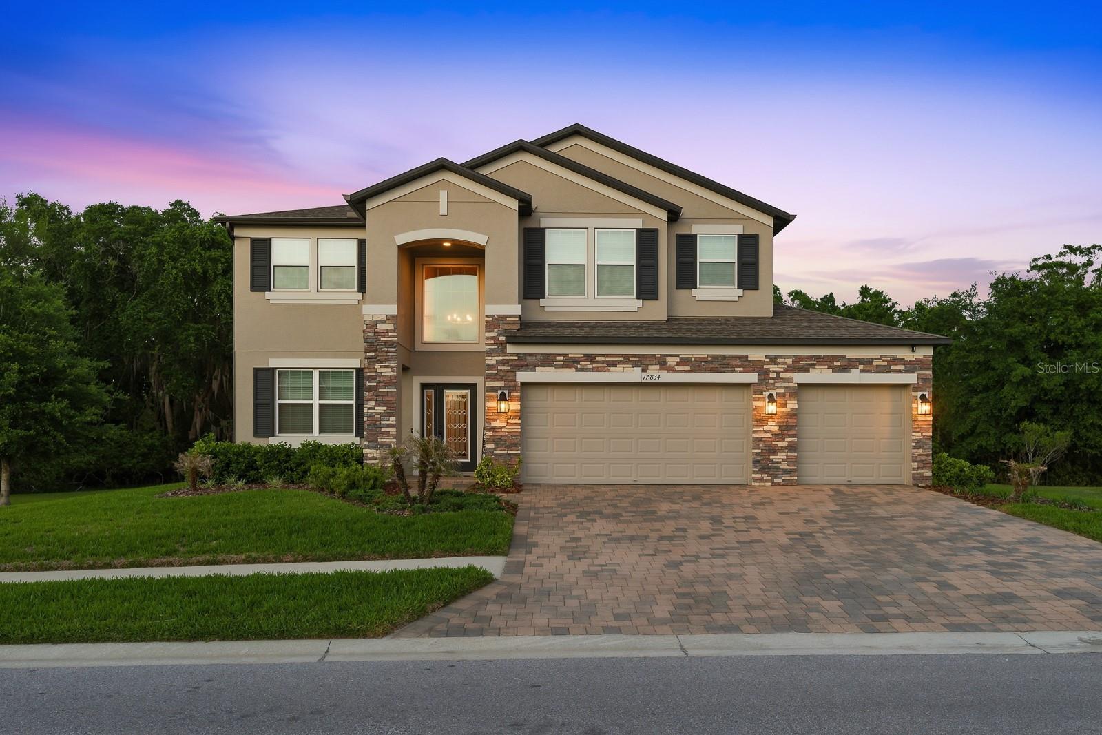 THE MOST PREMIUM HOMESITE IN TALAVERA CAN BE YOURS, FEATURING 1/4 ACRE CONSERVATION VIEW AND NO REAR OR SIDE NEIGHBORS!!! Showcasing just under $200k in upgrades, Luxury awaits over the bridge in the enclave of Talavera with this one-of-a-kind 5-bedroom, 4 full bath, 3 car garage with electric vehicle charger that also includes 2 Master Suites both upstairs and downstairs. This M/I Homes Mira Lago "C" model offers just under 4,000 square feet of living space on a fully fenced OVERSIZED 0.25-ACRE CORNER HOMESITE WITH PANORAMIC CONSERVATION VIEWS AND NO REAR OR DIRECT SIDE NEIGHBORS. Built in 2022, this home is an entertainer’s dream, boasting a large saltwater pool built in 2024, with heater and chiller and dual water sheer feature, extended trussed lanai with paver decking and a oversized screened enclosure. There are 6 DOORS THAT LEAD TO THE BACKYARD oasis, including 3 sliding pocket doors, pool bathroom access door and sliding glass doors off the deluxe kitchen. From the stone exterior and pristine landscaping to the elegant interior finishes, no detail has been overlooked. The first floor features a spacious owner's suite with direct pool views, walk-in closet, a luxurious en-suite bath with dual sink vanity and make-up vanity, garden tub, and step in shower with listello tile. The gourmet kitchen showcases upgraded 42-inch upper cabinets, granite countertops, cooktop, tile backsplash, oversized island, upgraded stainless steel appliances, built-in oven, butler’s pantry and oversized walk-in pantry. The expansive first floor has all wood-like plank tile flooring that opens to a spacious foyer and den/office, full pool bath with separate pool access, formal dining room and storage. The sprawling iron railing staircase leads right into the expansive game room with tray ceiling and luxury vinyl flooring, in-floor outlets and is flanked by access to multiple bedrooms—each with walk-in closet. The second floor features another spacious owner's suite with direct pool and conservation, tray ceiling, luxury vinyl plank, walk-in closet, linen closet, a luxurious en-suite bath with dual sink vanity and make-up vanity, and step in shower with dual shower heads including rain shower, shampoo niche, listello tile and private water closet. Additional highlights include: EV charging station in garage, Ring security system, laundry room with under stair storage and utility sink, a 3-car garage, gutters and thoughtfully placed A/C to the side of the home with pool equipment for peaceful poolside lounging. Zoned for top-rated schools, including Land O Lakes High, the highly desirable Talavera community has resort-style amenities including a zero-entry pool, splash pad, clubhouse, tennis and basketball courts, and regular food trucks. Enjoy easy access to US-41, SR-52 and the Suncoast Parkway. Schedule your private showing today—this one has it all!