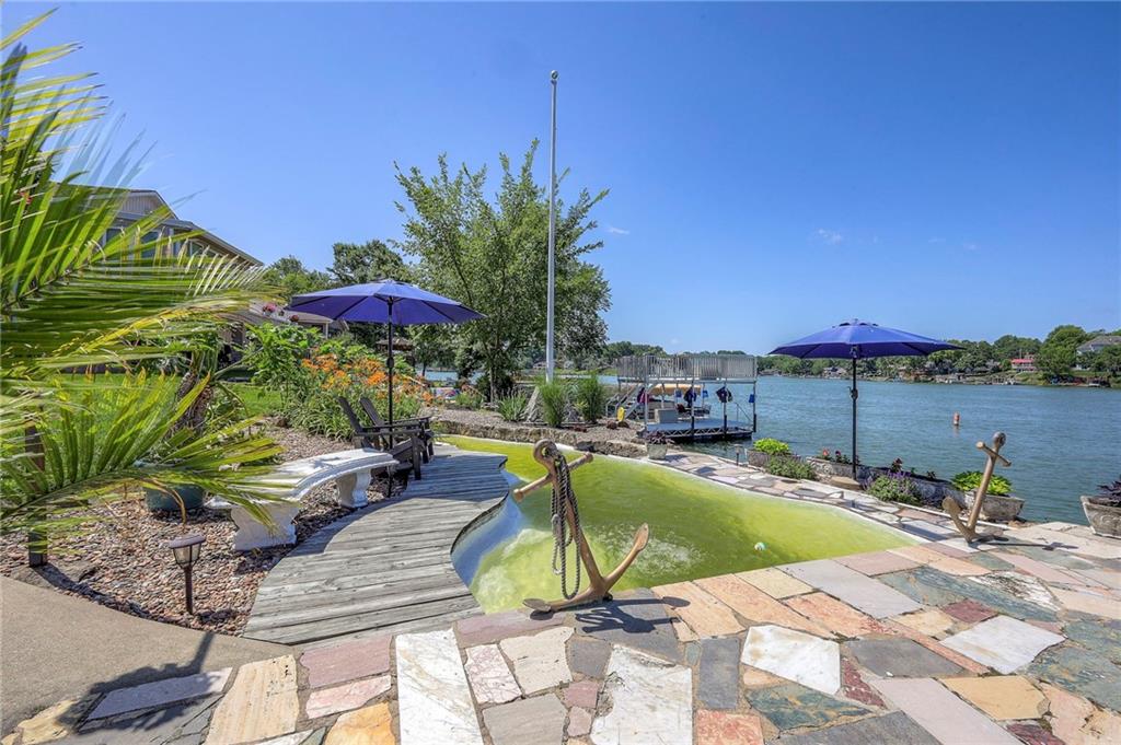 NEW PRICE of $614K!!!  Which is the current appraised value according to the APPRAISAL JUST COMPLETED!!!  And, If the buyer needs it, the seller will gladly share it!  This one-of-a-kind lakefront property is known by locals as the iconic home with the Lake Tapawingo–shaped swimming pool—yes, you read that right! The custom pool is uniquely filled by the lake itself, making it a landmark on the shoreline.
Inside, you’ll find 4 large, spacious bedrooms, 4 bathrooms, and a stunningly remodeled kitchen that opens up to panoramic lake views. Whether you’re prepping dinner or hosting guests, the view is always front and center.  The newly remodeled bar area and laundry room on the main floor look great too!
The outdoor entertaining space is a dream: perfect for sunset dinners, lazy summer lounging, and front-row seats to the best Fourth of July fireworks show on the lake. This home offers the rare combination of style, space, and setting in one unforgettable package on deep water and the main channel.