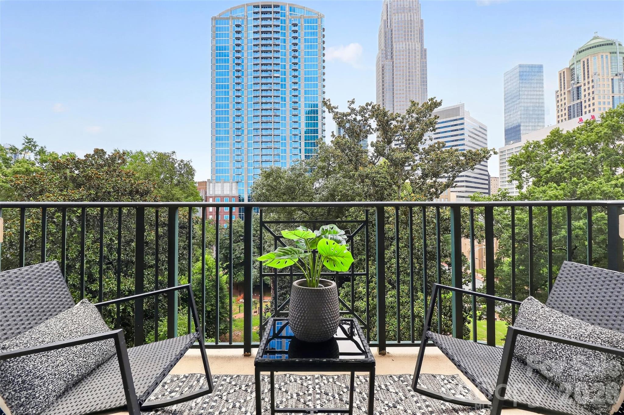 WOW!  What an amazing city view from this 7th floor, 2 bedroom/ 2 bath residence at the highly sought after Fifth and Poplar condominium complex.   Only a handful of residents are lucky enough to live on the 7th & 8th floor, but the 7th floor still gives you the penthouse feel with a COVERED balcony.  The interior boasts hardwood flooring throughout (carpet in one bedroom), detailed crown molding, granite countertops, and solid wood cabinetry. The desirable split-bedroom layout offers spacious bedrooms, each with it's own private ensuite bath and generous walk-in closet space. Primary suite is highlighted by a renovated bathroom with upscale Carrara marble that flows from the flooring into the updated shower. Kitchen features stainless steel appliances (all appliances including washer/ dryer and refrigerator to stay).Fifth and Poplar is situated in Uptown's Fourth Ward—walking distance to 4th Ward Park, Truist Field, Bank of America Stadium, Spectrum Center, dining, nightlife and more! Community amenities include a meticulously maintained 1-acre interior courtyard, resort style pool, putting green, pet park, full 24/7 fitness center, coffee bar, clubhouse with billiard room, 24/7 concierge, cyber café, and an ON-SITE Harris Teeter just an elevator ride away!!  You'll never want to leave - this is luxury uptown living at it's finest!