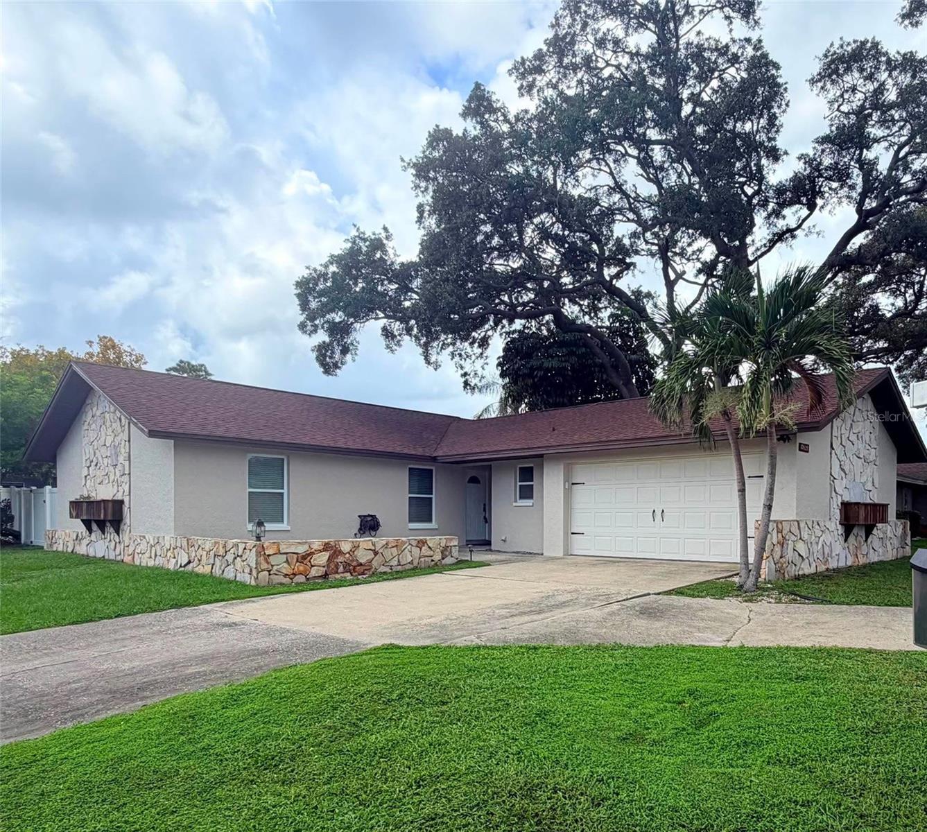 Welcome home to this beautifully remodeled Largo gem, situated high and dry on a spacious corner lot along a quiet cul de sac street. A convenient circular driveway welcomes you home, while the freshly painted exterior, mature shade trees and established neighborhood create fantastic curb appeal.Step inside and prepare to fall in love with the kitchen! Gorgeous leathered granite countertops, upgraded soft close cabinetry, abundant storage, lazy Susan corner shelving, subway tile backsplash and stunning live edge wood open shelving create a warm, modern farmhouse feel. One of the home's most unique details is the pendant light above the sink, handcrafted using wood sourced from the famous Buddha Coconut tree at the Ford Edison estate. A new Samsung 39 dBA ultra quiet dishwasher adds another thoughtful modern upgrade.The open and spacious living and dining area is made for gathering and entertaining, with a beautifully updated modern wood burning fireplace creating a striking focal point. Sliding glass doors lead to the covered back porch, perfect for morning coffee, evening cocktails, grilling or simply relaxing in the shade.The bedrooms feature attractive vinyl plank flooring, while the spacious primary suite offers its own beautifully updated ensuite bathroom with a large walk in shower. All new ceiling fans throughout add another fresh update.And don't overlook the garage! Fully insulated and equipped with its own mini split A/C system, this incredibly versatile space can function as a traditional garage while offering so many additional possibilities. Think workshop, home gym, hobby space, game room, office or additional flex space. Plus, it is already equipped with a Tesla Wall Connector charging station.Outside, the fully fenced backyard with 6 foot privacy fencing creates your own private retreat with plenty of room to entertain, gather around the fire pit, let the pets play or simply enjoy the Florida lifestyle.The location is hard to beat! Enjoy convenient access to the beautiful Gulf beaches, area schools, shopping, restaurants, parks and everything Largo and Pinellas County have to offer, while still coming home to a peaceful neighborhood setting.VA BUYERS, TAKE NOTE! Seller's existing VA loan may be assumable by an eligible Veteran buyer with sufficient VA entitlement for Substitution of Entitlement, subject to lender, servicer and VA approval. Ask your agent for additional details.Beautifully updated, high and dry, full of personality and packed with thoughtful upgrades. Come see your new home!!