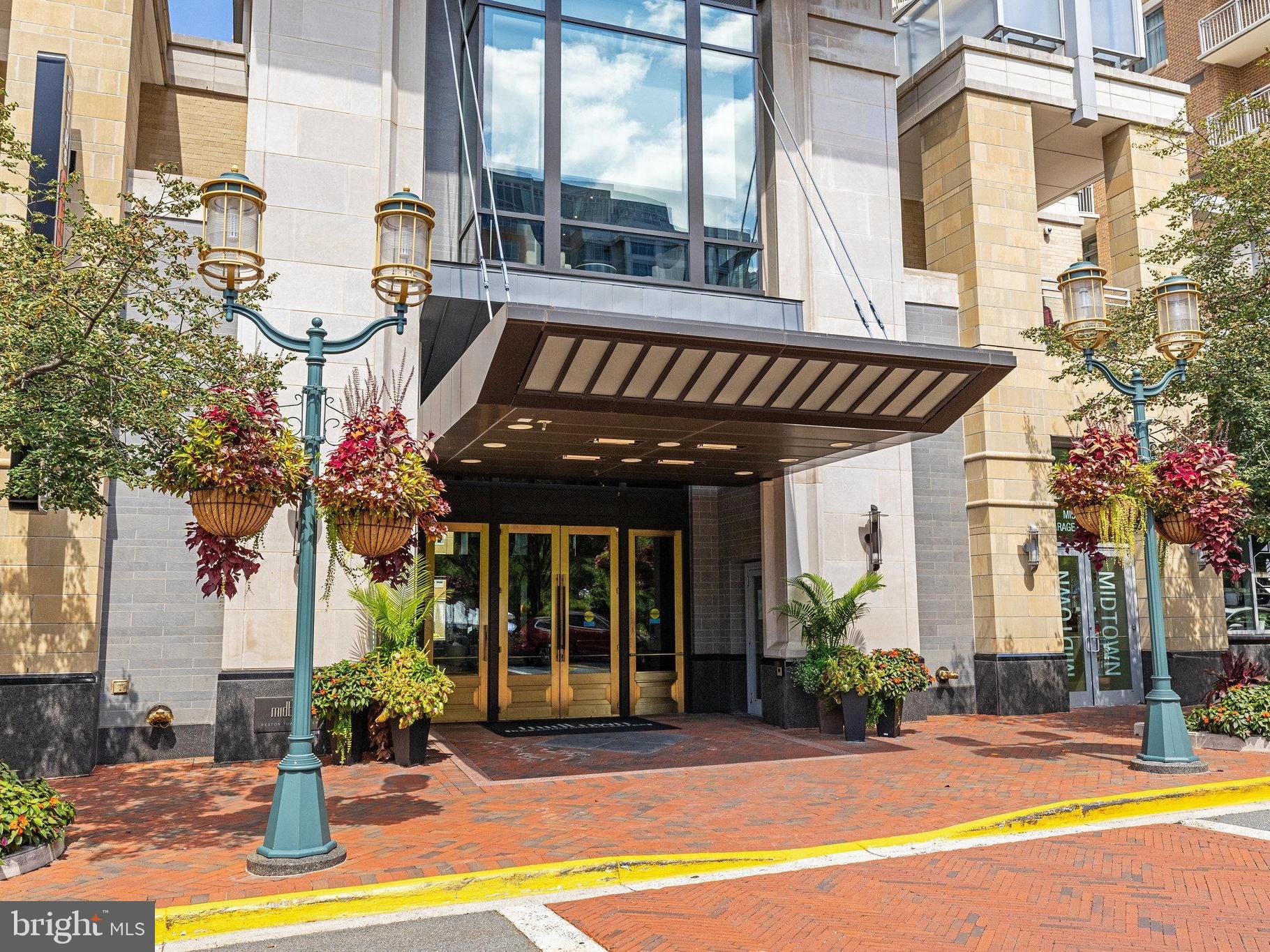 Experience exceptional luxury in this stunning 18th-floor residence at Midtown at Reston Town Center, where 2,283 square feet of beautifully designed living space, floor-to-ceiling windows, and sweeping panoramic views create an extraordinary home above the heart of Reston Town Center. An impressive sense of scale, abundant natural light, rich hardwood flooring, custom millwork, and refined finishes are showcased throughout this sophisticated three-bedroom, three-bath residence. The spacious and gracious open floor plan is equally suited to elegant entertaining and comfortable everyday living. The expansive living room features a beautiful gas fireplace and dramatic walls of glass, while the formal dining room makes a spectacular statement with its distinctive chandelier, custom details, and unforgettable views.  The gourmet kitchen is both beautifully appointed and exceptionally functional, featuring custom Aster Italia cabinetry with under-cabinet lighting, granite countertops, a large center island, premium stainless-steel appliances, including a Sub-Zero refrigerator and updated GE Monogram appliances, and gas cooking. The adjacent breakfast area and family room offer custom built-ins, including a beautifully appointed built-in bar with ample storage and two wine refrigerators. A sophisticated Lutron motorized shade system, with shades installed in the living room, dining room, and family room in June 2021 and additional shades added to the primary bedroom and sitting room in August 2026, provide effortless light control while complementing the home's refined design. The exceptional primary suite serves as a true retreat with its own sitting room and generous custom closets by Poliform Washington, beautifully designed with contemporary modern interiors that reflect Italian style and elegance, luxurious spa-inspired bath, and expansive windows overlooking the surrounding landscape. The second bedroom/office provides a quiet and sophisticated workspace, with custom built-ins and abundant natural light. An additional third bedroom offers privacy and comfort for family and guests. The views are exceptional from nearly every principal room, extending across Reston Town Center and beyond to the Blue Ridge Mountains. Two private balconies provide yet another vantage point for enjoying the ever-changing panorama, from brilliant daytime skies to spectacular sunsets. Added features include a laundry room with a full-size washer and dryer and an automatic water detection and shutoff system, two deeded parking spaces located across from the elevator on the G2 garage level, and a double deeded storage unit on the G4 garage level, directly behind the elevator. Midtown offers an unparalleled collection of amenities, including 24-hour concierge service, resort-style outdoor pool and hot tub, state-of-the-art fitness center, private movie theater, library, conference room, elegant great room, outdoor terraces with grilling areas, two guest suites, guest parking, and professional on-site management. Ideally located in the heart of Reston Town Center, this exceptional residence is perched amid an outstanding selection of restaurants, luxury shopping, entertainment, parks, the W&OD Trail, Reston Town Center Metro Station, Reston Hospital Center, and major commuter routes including the Dulles Toll Road, Route 7, Fairfax County Parkway, and Dulles International Airport.