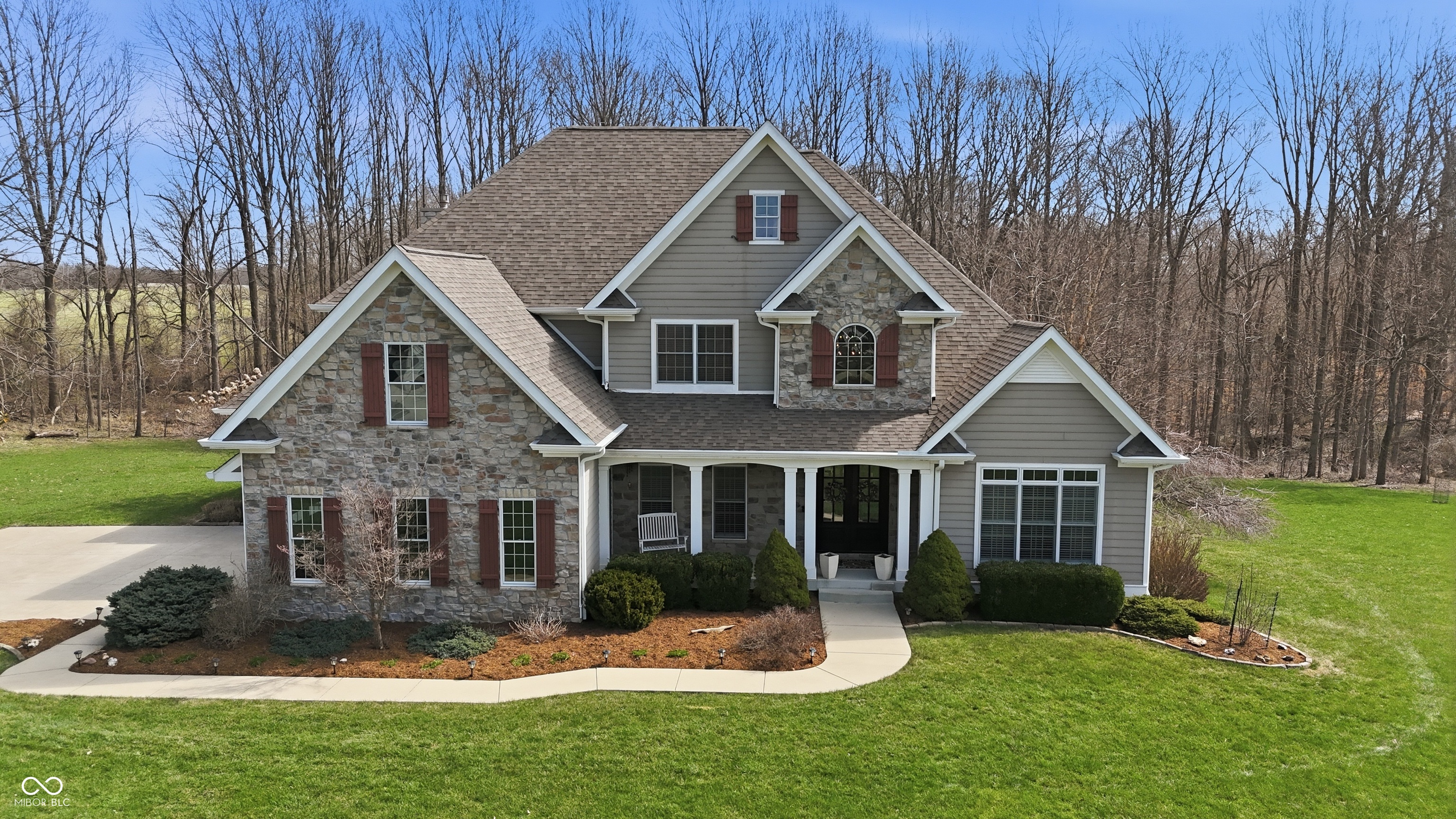 Discover 3950 E Larry Wayne Dr, Bloomington, IN. An exceptional opportunity for those seeking luxury in a classic everyday lifestyle, boasting an amazing open floor plan design crafted with top-tier materials. The main rms are distinguished by an impressive array of ceiling designs inc. beamed, coffered, & vaulted ceilings, all complemented by elegant crown molding. A fireplace provides a focal point, while meticulously crafted built-in shelves offer both aesthetic appeal and practical utility. Culinary pursuits are within the meticulously appointed kitchen, featuring stone countertops, cherry and cream cabinets that frame a spacious layout. It includes a kitchen island with prep sink, kitchen bar, and a peninsula, all designed to enhance gathering. Equipped with a double oven, a stovetop beneath a custom range hood, wine cooler, backsplash and under cabinet lighting. A planning desk for the day's activities to be displayed and a corner beverage nook between kitchen and formal dining room. Working from home or needed quiet space for recording? There are several home office location setups possible including the main level home office. It offers a vaulted ceiling and big windows for natural light. Downstairs you'll find a craft room or quiet podcasting rm. The main level primary bedroom offers a sitting area, tray ceilings, crown moulding. The ensuite private bath features double walk in closets, split double sink design, walk in tile shower and sep. tub overlooking the wooded backyard. Upstairs you'll find an ensuite bedroom with builtin bench seat under the window, 2 addtl bedrooms w/ shared full bath and a lrg storage rm above garage. Main level laundry room that is also a mudroom from the outside and attached three car garage area. There are cabinets for storage, built in coat storage and a utility sink. The basement offers a large family rm, den, craft and office space, built in bar, 5th bedroom with full bath alongside. Screened in deck fenced yard.