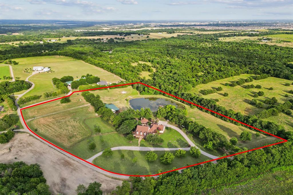 Rare opportunity to own a private 10-acre luxury family compound in the heart of McKinney with NO City Taxes and current ag exemption. Designed for multi-generational living and resort-style entertaining, this exceptional property features a 5,344 sq ft main residence, separate 1,933 sq ft guest house, private pond, horse-ready acreage, and stunning outdoor living spaces just minutes from McKinney conveniences. The main home offers 6 bedrooms, 4.5 baths, executive study, formal dining, expansive living room with stone fireplace and built-ins, and a gourmet kitchen with granite countertops, center island, gas cooktop, double ovens, stainless steel appliances, walk-in pantry, and large breakfast area. Downstairs primary suite features bay window sitting area, dual walk-in closets, soaking tub, separate shower, and dual vanities. Upstairs includes a game room with built-in bar and beverage fridge, bonus space, four additional bedrooms, and two full baths. Attached 4-car garage. The separate guest house is ideal for extended family, guests, private office, or retreat-style living with open-concept living area, kitchen with granite countertops and stainless appliances, downstairs primary suite, upstairs game room, two additional bedrooms, two full baths, and large attached storage or garage area.Resort-style outdoor living includes a pool with waterfall, diving board, spa, expansive covered pavilion with bar, grilling station, fireplace, beverage fridge, multiple patios, fire pit, mature trees, fenced horse area, and peaceful private pond. Beyond the main living areas, the property offers fenced horse-ready acreage, a private pond, mature trees, open green space, and the privacy of a true Texas retreat while remaining conveniently close to shopping, dining, and major commuting routes. A rare blend of luxury, privacy, flexibility, and Texas lifestyle living.