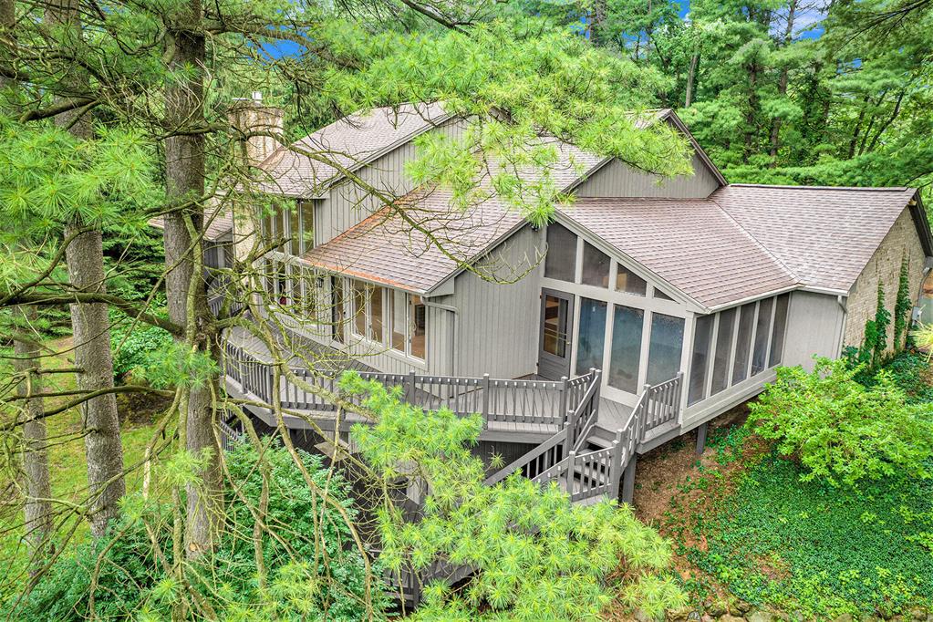 Tucked among mature trees in a quiet, secluded setting, this beautifully updated Saginaw Hills home offers serene pond views, a flexible layout, and thoughtful upgrades so it's ready for you to move right in with plenty of time to host summer BBQs and get settled before school starts! Step onto the covered front porch and into the dramatic two-story great room, where a statement fireplace and a wall of windows looking out onto the water create a warm and inviting focal point. Adjacent to the great room is the brand-new luxury kitchen, featuring slim shaker wood cabinetry, quartz countertops, high-end stainless-steel appliances including a double oven, and a large island with breakfast bar seating. The kitchen sink, refrigerator, and pot filler share a reverse osmosis system, and abuilt-in wet bar with beverage cooler makes entertaining a breeze. The dining area is surrounded by windows and opens to a spacious deck overlooking the pond, while a screened-in porch offers shaded, insect-free outdoor enjoyment. Timeless wood floors run throughout the main living spaces. Savor one-level living with three bedrooms and two full bathrooms on the entry level. The luxurious primary suite offers a private deck with tranquil views, a walk-in closet, and a completely renovated bath with dual vanity, soaking tub, separate rain shower, and heated floors. Two additional bedrooms with walk-in closets share an updated hallway full bath. The main level also includes a bright front study/den and a mud/laundry room with extra storage adjacent to the attached two-car garage with new door and myQ smart opener. Upstairs, a versatile loft overlooks the great room and is ideal for a playroom or home workspace. The walkout lower level provides exceptional space and versatility, with a generous family/rec room with fireplace, an additional bedroom and full bath, and a flex room with access to the lower deck and yard - ideal as a private guest or in-law suite. There's also a massive unfinished area ready for your customization. Outside, enjoy