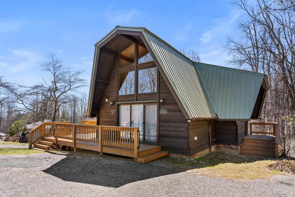 Escape to this fully furnished 4-bed, 3-bath cabin in the gated Cascade Mountain community in Fancy Gap, VA. The resort offers a playground, pool, basketball and tennis courts, fishing pond, and guest house. The cabin has new app-controlled mini-splits, a metal roof, and expansive, freshly stained decks. The main floor features a spacious living area with soaring ceilings and a cozy fireplace. There is at least one bedroom and bathroom on every level, offering flexibility and privacy. The second floor includes a loft for extra guests and a bedroom with a balcony offering serene wooded views. The basement, accessed by a spiral staircase, serves as a second living space or MIL suite, complete with a kitchen, bedroom, living area, and bathroom with tile and granite finishes, plus direct deck access. Conveniently located, it's just 45 minutes to Winston-Salem, NC, 1 hour and 45 Minuets to Roanoke, VA, 1 hour and 40 minutes to Charlotte, NC, and 2 hours and 20 minutes to Raleigh, NC.