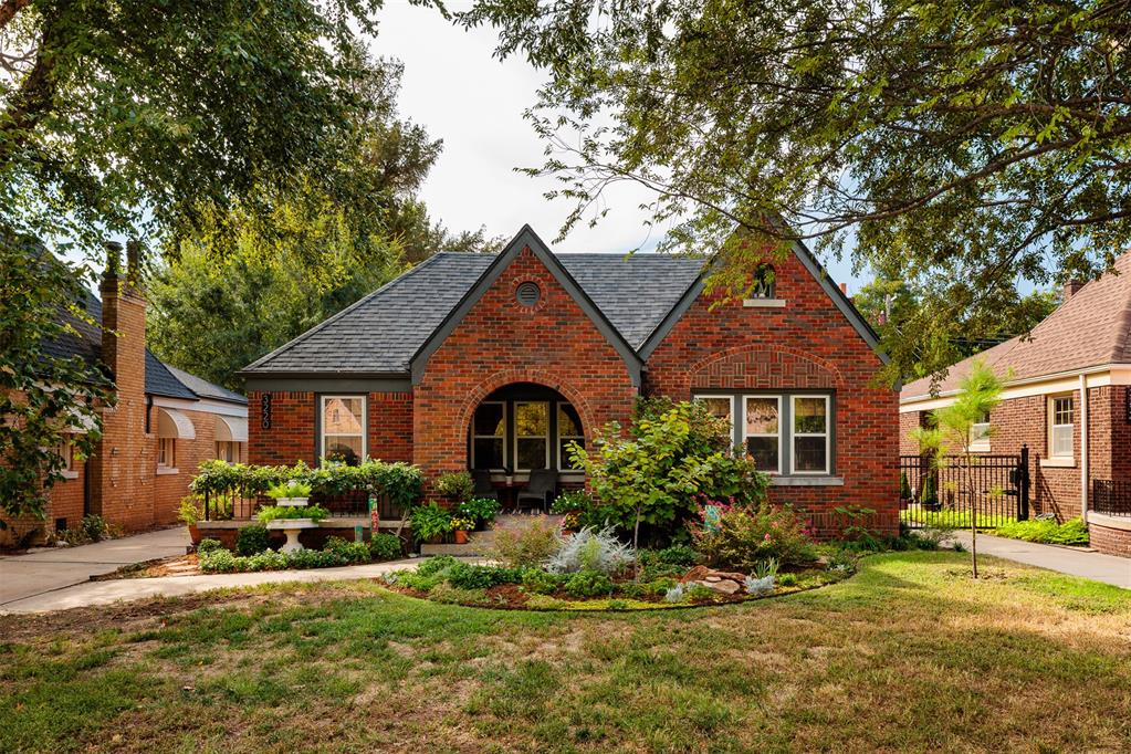 This brick Tudor bungalow in Oklahoma City’s historic Linwood Place has all the character you hope to find in an older home. Steep front gables and graceful brick arches give the exterior a storybook quality. The covered front porch adds a gracious place to slow down, visit with neighbors or linger over coffee. Inside, beautiful wood windows, hardwood floors, stained woodwork, period light fixtures and interior arches preserve so much of what makes the home distinctive. The living room features a vaulted tray ceiling and a fireplace surrounded by original Calco tile, a detail you simply can’t recreate. Natural light pours through the wood windows and carries into the adjoining dining room. The renovated kitchen feels right at home with the architecture, featuring full-overlay cabinetry, honed marble countertops, unlacquered brass hardware, a farmhouse sink and built-in desk. Two bedrooms and a full bath are on the main floor. Upstairs, a beautifully converted attic serves as the third bedroom (included in overall square footage count), with its own powder bath and flexibility to also work as an office, playroom or bonus space. And then there’s the backyard. Mature landscaping, garden beds, flagstone and gravel paths and a hammock spot make the garden every bit as appealing as the house. The large covered patio is made for dinners outside and evenings with friends, while the detached two-car garage adds the practicality everyone hopes to find. A new HVAC system and a fully paid-off solar system bring meaningful modern efficiency to this historic home, with seller reporting exceptionally low electric costs. Linwood Place is known for its tree-lined streets and historic architecture, all just minutes from the Plaza District, Paseo, Midtown and Downtown OKC with easy highway access. Original where it matters, updated where it counts and full of personality throughout. What a lovely way to live.