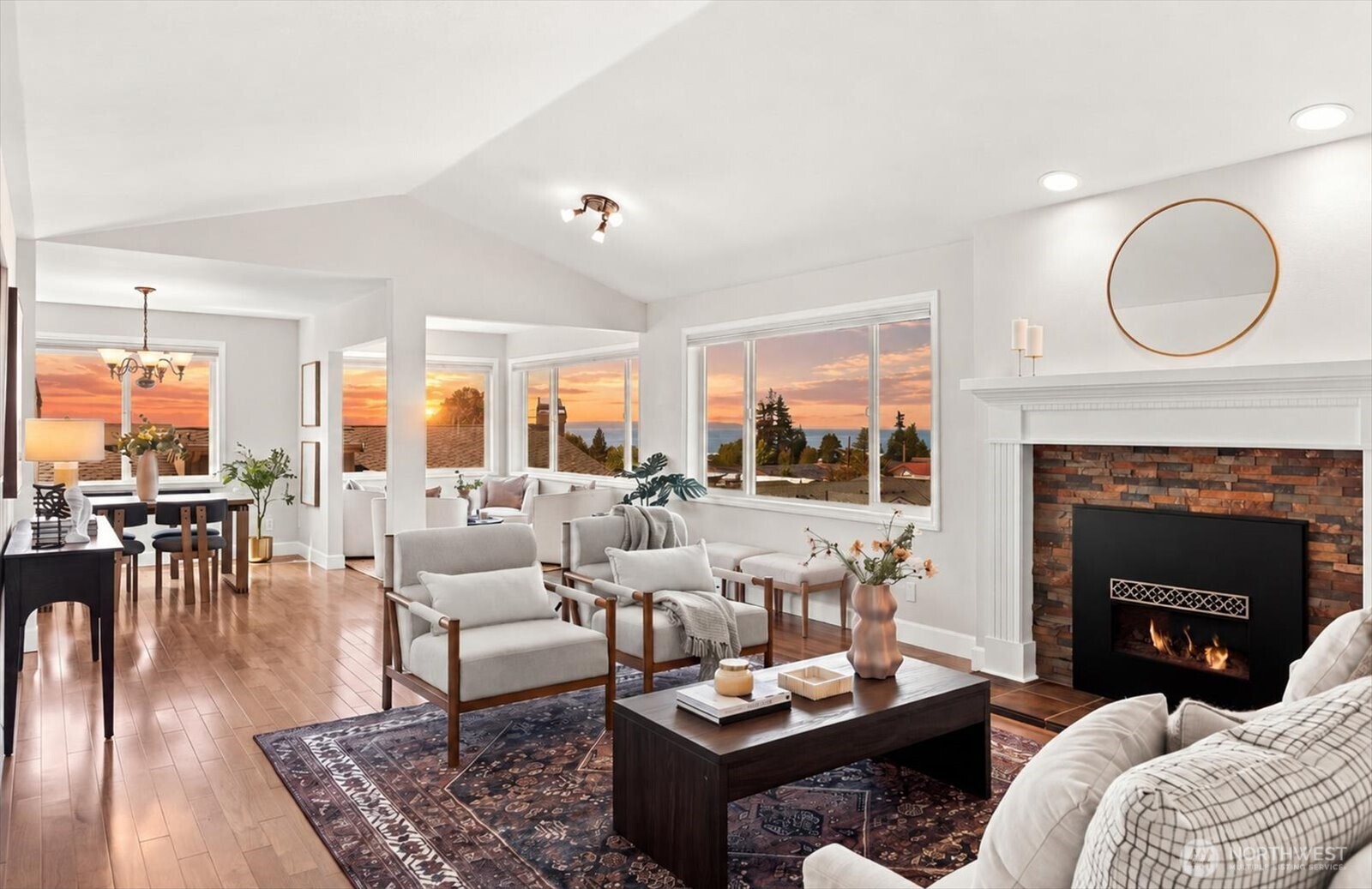 Imagine ending every day with a spectacular Puget Sound sunset from virtually every window of your top-floor Corner unit Edmonds condo. This spacious and thoughtfully updated one-level residence offers panoramic views stretching across Puget Sound to the Olympic Mountains, Whidbey Island, and beyond. The unique circular floor plan creates an inviting flow from room to room, highlighted by a vaulted living room with electric fireplace, comfortable sitting area and dedicated dining space. The bright eat-in kitchen features granite countertops and plentiful pantry storage, making everyday living a pleasure. Wake up to water views in the spacious primary bedroom, complete with a private bath, two generous closets, spa-like shower and separate water closet. A second bedroom and full bath provide a private retreat for guests. The conveniently located laundry room offers additional storage. Enjoy the security and ease of two garage parking spaces, private storage and elevator access. Located in the coveted Edmonds Bowl, you are minutes from charming shops, exceptional dining, ferry service to Kingston and the Sounder train to Seattle. A truly special opportunity to call Edmonds home!