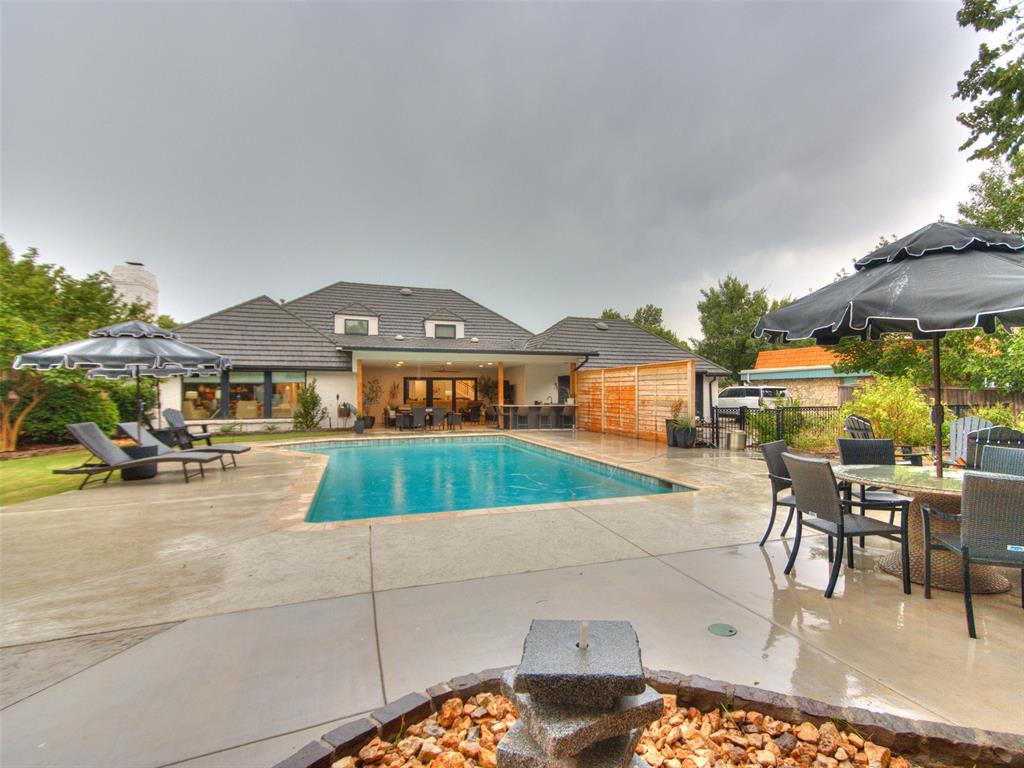 Experience exceptional luxury living in one of Northwest Oklahoma City's most sought-after neighborhoods. Situated on an expansive cul-de-sac lot with a breathtaking wooded creekside setting, this stunning executive home is designed for both everyday comfort and unforgettable entertaining. The heart of the home is an extraordinary chef's kitchen featuring a professional-grade gas range, dual refrigerators, wine refrigerator, built-in coffee maker, nugget ice machine, custom cabinetry with beautiful walnut accents, and premium finishes throughout. The open-concept design flows seamlessly into two spacious living areas and an inviting bar, creating the perfect space for hosting family and friends. Rich white oak hardwood floors add warmth and elegance throughout. The thoughtfully designed floor plan offers five bedrooms and four full bathrooms, including two bedrooms and two baths on the main level. The luxurious primary suite provides a private retreat with dual walk-in closets and a beautifully appointed en-suite bath. Upstairs, you'll find three additional bedrooms and two full bathrooms, offering plenty of room for family and guests. Step outside to your own private resort. The expansive covered patio features a fully equipped outdoor kitchen overlooking a sparkling in-ground pool and the picturesque wooded creek beyond. Whether you're enjoying a quiet evening or entertaining a crowd, this outdoor living space is truly exceptional. Adding even more versatility is a beautifully appointed detached guest house with stunning creek views. Ideal for multi-generational living, an elderly parent, long-term guests, or a private home office, it includes a high-end open kitchen, comfortable living area, bedroom, and full bathroom. This remarkable property combines luxury finishes, an exceptional floor plan, incredible outdoor amenities, and a highly desirable Northwest Oklahoma City location—creating a rare opportunity to own one of the area's finest homes.