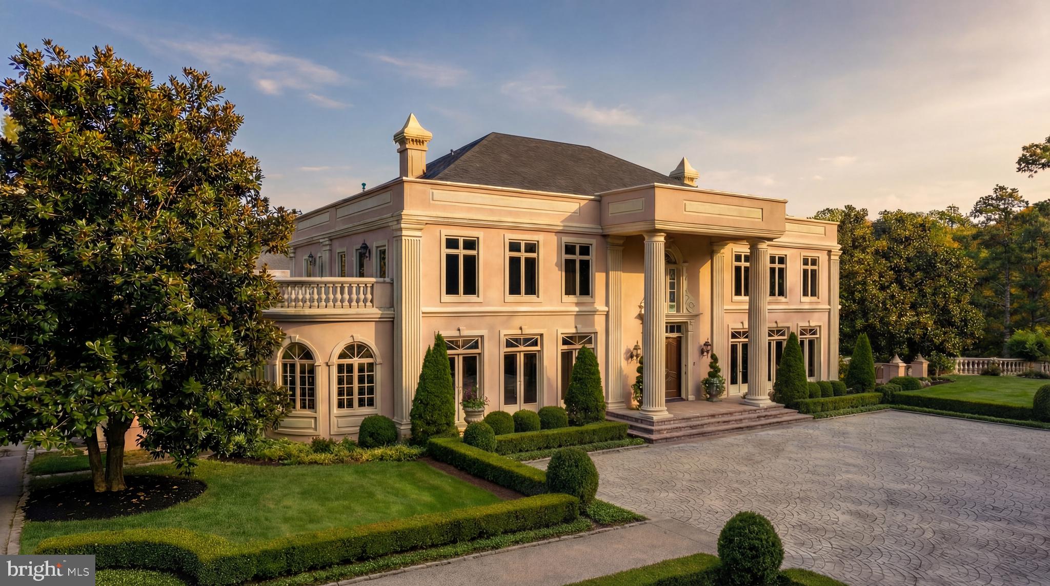 Discreetly tucked away at the very end of one of Great Falls’s most prestigious enclaves, the coveted Cornwell Farms neighborhood, where only a handful of estate homes are dotted across verdant rolling hills, 651 Mine Ridge Road represents an opportunity unlike any other. Situated on 5.92 parklike acres, the grand estate is introduced by a sprawling paver motor court, which augments the façade’s symmetry and grandeur. Intricate detailing frames the gracious entry and arched Palladian window beneath a towering double-height portico supported by substantial Doric columns.Double doors part to introduce a stunning foyer, framed by sweeping double staircases with a shimmering crystal chandelier overhead and classically inlaid marble floors beneath. An expansive floor plan spans over 17,000 square feet of exquisitely detailed living space. Formal living and dining rooms flank the entryway in a traditional center hall configuration. The former features a fireplace and flows into a dignified study, lined with a curved wall of windows and rich built-ins. Both spaces showcase intricate millwork and parquet flooring.The double-height great room is centered within the main level, capped by a stunning coffered ceiling and offering verdant views, as well as access to the rear terrace. It flows into the formal library, a dignified retreat featuring a fireplace framed by built-ins. A transverse gallery, whose arched ceiling is bathed in the soft glow of ambient illumination, spans the entire width of the main level.On one end, the informal areas comprise a generous kitchen and mudroom with access to the attached three-car garage. On the opposite end is the main-level primary bedroom, featuring two walk-in dressing rooms and a lavish bathroom with all expected accoutrements. Dual powder rooms, a coat closet, and a wet bar complete the list of entertaining amenities on the main level.Four large bedrooms, each equipped with a walk-in closet, three baths, and a rooftop terrace, are found on the upper level. The top level comprises a large bonus room, a full bathroom, and a balcony with sweeping views of the Northern Virginia countryside. All levels are accessible by private elevator.Designed for elaborate large-scale gatherings, the lower level’s central ballroom is flanked by two symmetrical salons and opens onto a covered terrace. Two additional bedrooms, two full baths, a billiards room, and a catering kitchen complete the lower level.The grounds, a true highlight of the estate, are a combination of rolling hills, open plains, towering mature foliage, and integrated hardscaping. Set within Cornwell Farms and just over a mile from Great Falls Village, the location offers a rare blend of seclusion and accessibility. A stunning home perched on an unparalleled lot in the heart of one of the Capital Region’s most sought-after enclaves, 651 Mine Ridge Road offers an unprecedented and versatile opportunity for the visionary.