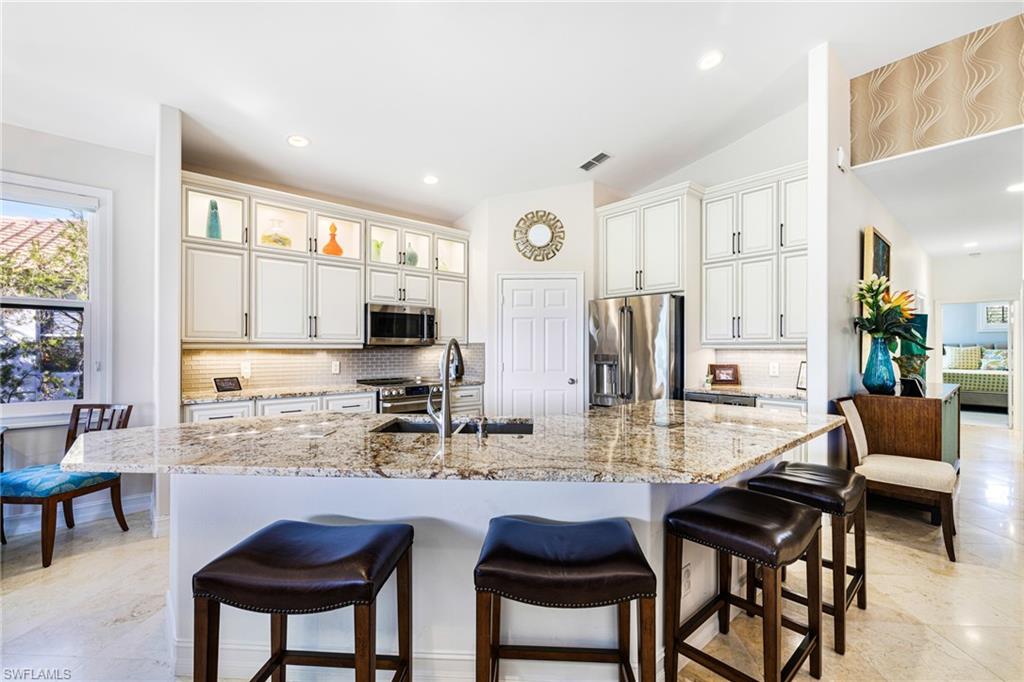 GOLF INCLUDED!!! Welcome to your dream home in Pelican Sound Golf & River Club! This top-floor, corner Carriage Home features three bedrooms, a den, and a spacious two-car garage. You’ll be captivated by the stunning views of the lake, golf course, and wetlands preserve from the expansive wraparound lanai—perfect for soaking in those breathtaking sunsets. The recently renovated custom kitchen boasts high-level granite countertops, elegant double-stacked display cabinets, and a two-zone wine cooler for 48 bottles. Luxury touches include travertine flooring, designer carpeting, and top-of-the-line GE Café appliances. With electric storm shutters, hurricane-rated windows, and a remodeled master shower, this home is as secure as it is beautiful. Ownership includes bundled membership with 27 championship golf holes, tennis, pickleball, a state-of-the-art fitness center, six pools, and even a water taxi to the beach. Ideally located close to Coconut Point with its array of shopping and dining, Lee Health Center, Hertz Arena, Miromar Outlets, and just minutes to the airport, this home offers the ultimate active lifestyle in Southwest Florida. Don’t miss your chance—schedule your showing today!