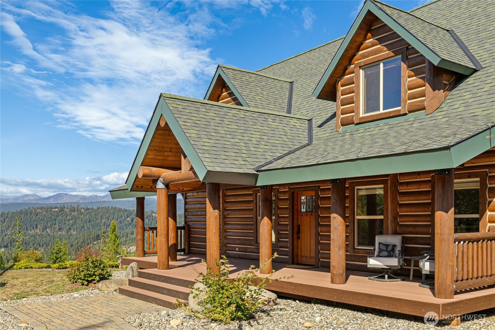 Classic log construction, a welcoming covered entry, and multiple outdoor living spaces complement the home’s mountain setting.