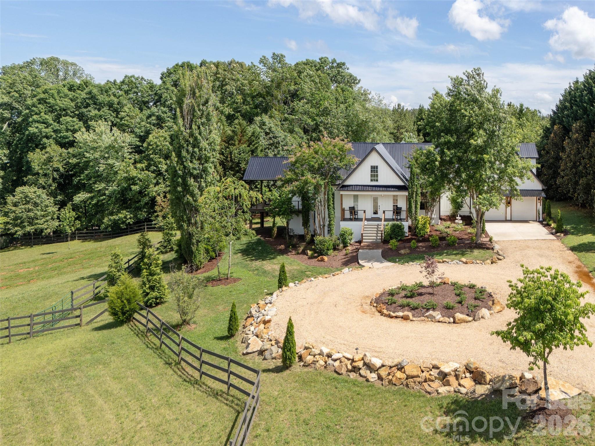 Set on more than 12 picturesque acres just minutes from the world-renowned Tryon International Equestrian Center, this exceptional farmhouse estate offers an unmatched blend of luxury mountain living, equestrian functionality, and incredible investment potential. Whether envisioned as a private family compound, boutique event venue, luxury Airbnb retreat, or working equestrian property, the possibilities here are truly endless. Designed with horse enthusiasts in mind, the property features three fenced pastures and a well-equipped two-stall barn complete with tack room and hay/shavings storage, creating a turnkey setup for equestrian use. The expansive grounds are beautifully landscaped and centered around one of the property’s most breathtaking features — a luxurious custom creek and waterfall installation stretching over 170 feet and showcasing more than seven cascading waterfalls, creating a truly serene and unforgettable setting rarely found in the area. The spacious 7-bedroom, 5-bathroom residence offers exceptional flexibility for multigenerational living, guest accommodations, retreat-style hosting, or income-producing opportunities. Several of the bedrooms can easily serve as bunk rooms, offices, fitness spaces, media rooms, or private guest suites, allowing the home to adapt seamlessly to a variety of lifestyles and business ventures. Adding even more versatility is the private 1-bedroom, 1-bath apartment above the garage — ideal for guests, caretakers, rental income, or extended family living. Enjoy peaceful mornings and mountain sunsets from the expansive side deck overlooking the rolling countryside and surrounding mountain views. Located just a short drive from one of the country’s premier equestrian destinations, this rare Western North Carolina property combines natural beauty, privacy, functionality, and commercial potential in one extraordinary offering. Additional highlights include brand-new siding, fresh exterior paint, making this property move-in ready while still offering room to personalize and expand its vision. Furnishings negotiable. Approximately 1,706 square feet of total HLA unpermitted.
