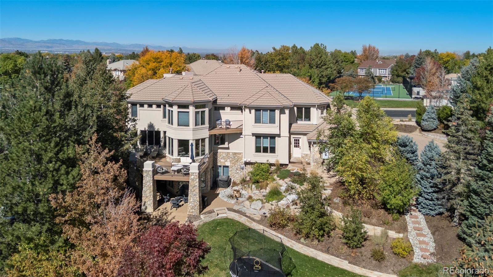 Welcome to 298 Fairchild Drive, a stunning residence nestled in the prestigious gated community of Highwoods in Highlands Ranch, Colorado. This exceptional property, boasting 6,962 square feet, has been meticulously remodeled on the main levels and is ready for you to enjoy almost $600,000 in updates!Upon entering, you are greeted by a grand foyer that seamlessly flows into the great room. This space features a cozy fireplace and provides access to a wrap-around deck, offering mountain views. The kitchen is a chef's dream, equipped with top-of-the-line SubZero and Wolf appliances, custom vent hood, two dishwashers, pantry, large center island, separate prep space for coffee, wine or entertaining, and a breakfast nook with open space views. The main level also includes a formal dining room, perfect for hosting gatherings, and a spacious office with double doors, ideal for working from home. The large laundry/mudroom is equipped with built-ins with storage, and a newly added walk-in pantry. A powder bath with modern vanity and lighting completes the main level.The upper level features a luxurious primary retreat with built-ins and a fireplace. The en-suite bath provides an oversized shower, bathtub, a private balcony, and a walk-in closet with added laundry hook-ups. Three additional bedrooms, each with private baths and custom walk-in closets, complete the upper level.The walk-out basement is an entertainer's paradise, featuring a spacious family room with a bar, access to a covered patio and a theater room with tiered seating and a 108" projector screen. The ample storage space offers the potential to add a bedroom or workout room.Situated on a private lot that backs to open space, the backyard includes a water feature, professional landscaping and multiple outdoor living spaces. The location can't be beat, offering convenient access to neighborhood tennis courts and pool, and nearby trails, shopping, dining, and award-winning schools.