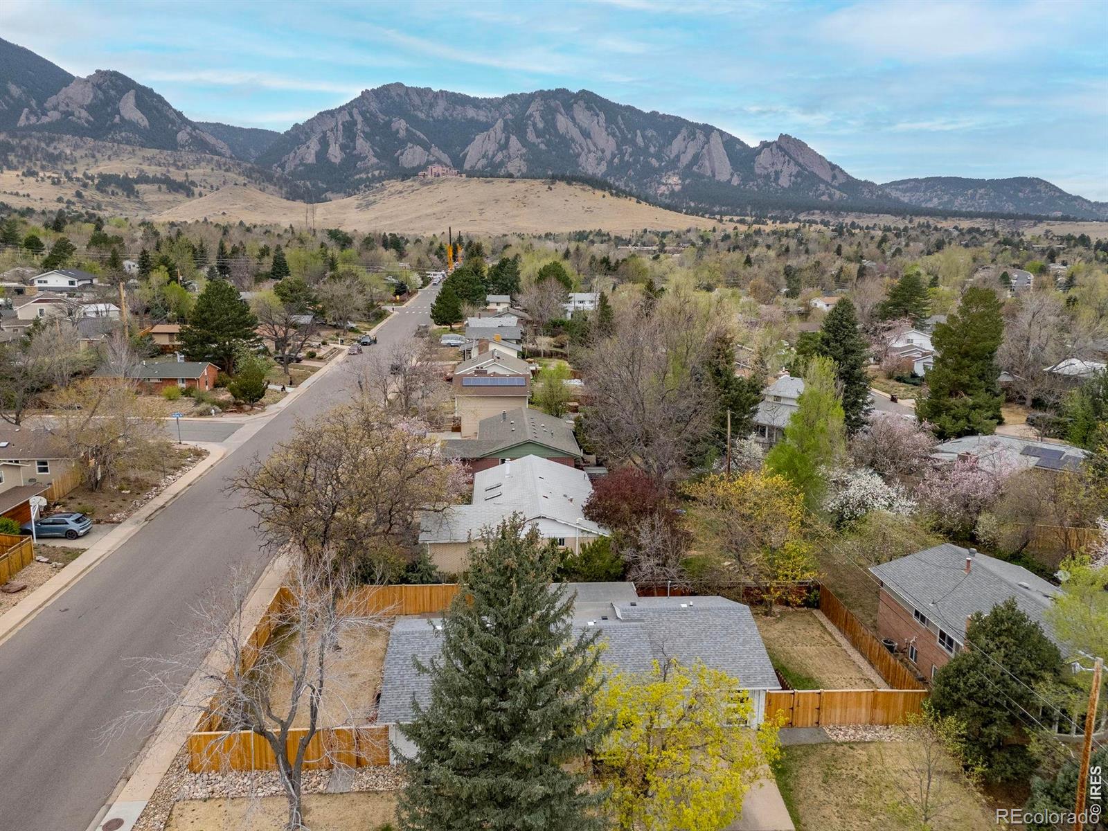 Nestled on a spacious corner lot in one of Boulder's most coveted neighborhoods, 1095 Edinboro Drive is a stunning ranch-style retreat that seamlessly blends elegance, comfort, and functionality. With its timeless brick exterior, mature shade trees, and breathtaking Flatirons views, this home exudes curb appeal and an invitation to enjoy the Colorado lifestyle both indoors and out. Step inside to discover a thoughtfully designed interior brimming with high-end finishes and modern conveniences. The heart of the home is undoubtedly the chef's dream kitchen, featuring top-of-the-line appliances: a Sub-Zero wine cooler, a matching Sub-Zero fridge and freezer with cabinet door panels, a Wolf six-burner range with a grill and griddle, a Wolf warming oven, and dual Asko dishwashers. Quartz countertops and custom-built ins, including an epic bench with storage in the dining area, complete this gourmet space. Entertain effortlessly with the open layout that flows into the sunlit main living area, adorned with solid oak floors, built-in speakers, and custom window coverings. The main floor primary suite offers a private sanctuary with luxurious touches like built-in speakers and custom lighting. A NanaWall folding glass wall seamlessly connects indoor and outdoor living, opening to a composite deck and a beautifully landscaped, level yard. Whether hosting a summer barbecue or savoring a quiet evening under the stars, the new privacy fencing ensures your outdoor oasis remains just that-private. Additional features like a Lennox smart thermostat, whole house humidifier, an oversized two-car garage, and under-sink water filtration in the kitchen underscore the home's practicality and attention to detail. From the oversized garage to the custom light fixtures, every corner of this home reflects quality craftsmanship and thoughtful upgrades. This exceptional property is more than just a house-it's a lifestyle. Don't miss the chance to make 1095 Edinboro Drive your next home.