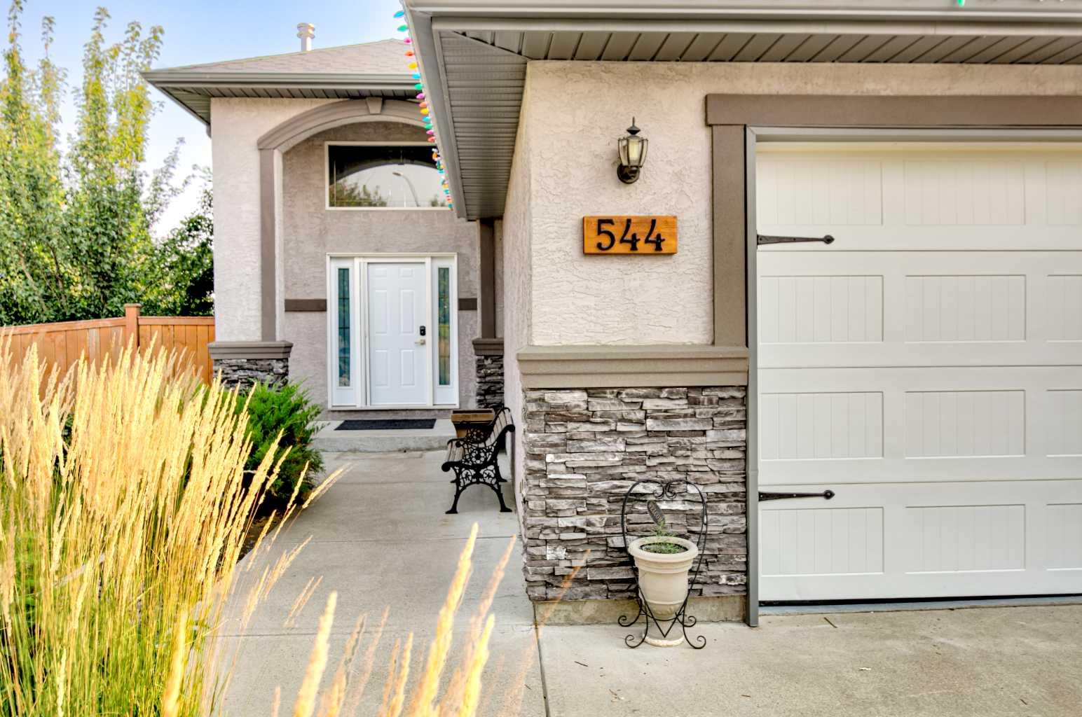 Welcome to this beautifully maintained 1,400 sq. ft. bi-level by Greenwood Homes, ideally situated on a desirable corner lot in an established south Lethbridge neighbourhood. This impressive 4-bedroom, 3-bathroom home combines quality construction, generous living spaces and an exceptional backyard retreat.A spacious foyer welcomes you into the bright, open-concept main floor, where vaulted ceilings, large windows and engineered walnut hardwood flooring create a warm and inviting atmosphere. The kitchen features matching maple cabinetry, granite countertops and plenty of workspace, flowing seamlessly into the dining and living areas. The living room is highlighted by a beautiful fireplace, while the spacious primary suite offers its own fireplace, walk-in closet and 4-piece ensuite with a large soaker tub. A second bedroom, full bathroom and convenient main-floor laundry complete this level.The fully developed lower level feels anything but like a basement, thanks to its large windows and abundance of natural light. A massive family and recreation room provides plenty of space to relax or entertain with bonus features of a wet bar and gas fireplace. Two additional large bedrooms and another full 4-piece bathroom make this level ideal for teenagers, guests or a growing family.Outside is where this property really sets itself apart. Step from the home onto the covered rear deck, perfect for enjoying the outdoors in almost any weather. Below, the fabulous patio and entertaining area creates a backyard retreat complete with a pergola. The fully fenced and beautifully landscaped yard features mature trees, shrubs and perennials, underground sprinklers, raised garden beds constructed from quality Prairie Cedar and additional storage space.Additional highlights include central air conditioning, custom window coverings, soundproofing underlay beneath the main-floor hardwood, and an impressive 24' x 22' heated attached garage.With approximately 1,400 sq. ft. above grade plus a fully developed lower level, exceptional outdoor living spaces and a sought-after corner-lot location, this is a home that offers far more than you might expect from a traditional bi-level. Beautifully cared for, extensively upgraded and ready for its next owner—this is one you'll want to experience in person.