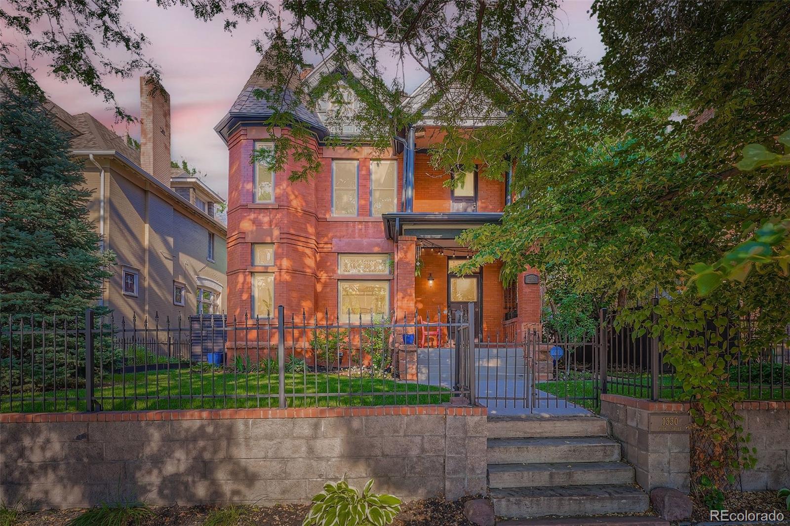 Step into timeless elegance w/this beautifully preserved & thoughtfully updated Queen Anne-style home in coveted Congress Park. Built in 1893, this 3-story architectural treasure blends turn-of-the-century charm w/modern comfort. The striking exterior—with patterned half-timber gables—sets the tone for the craftsmanship within. Inside, intricate original woodwork surrounds three cast-iron fireplaces, the staircase, and formal front entry. A restored staircase, stained glass windows, & exposed brick add to the home’s historic character. The spacious main level features 10’ ceilings & oversized windows that fill the home w/natural light. The living room offers a large front window & gas fireplace, while the adjacent intimate parlor—with its own fireplace & original wood pocket doors—makes an ideal study or retreat. The open-concept kitchen features quartz countertops, 2 sinks, ample cabinetry, a cooktop, & flows seamlessly into the dining area. Upstairs, find a custom hand-painted bedroom, a remodeled secondary bath, & a serene primary suite w/walk-in closet & five-piece bath w/clawfoot tub. A bonus space w/a decorative fireplace offers flexible living—perfect as a playroom or office. On the 3rd level are 2 additional bedrooms, plus a cozy reading nook w/built-in seating & shelving. The finished basement includes a bedroom, full bath, laundry room, & a large storage area—ideal for guests, hobbies, or multi-generational living. Outdoors, enjoy a private oasis on this double lot w/mature trees, lush landscaping, & a flagstone patio perfect for relaxing or entertaining. Sprinkler systems in the front & back keep everything vibrant. A detached 2-car garage & an extra alley parking spot add convenience. Just steps from Congress Park, Cheesman Park, the Denver Botanic Gardens, local shops, & restaurants—w/easy access to Downtown & Cherry Creek—this home truly has it all. Don’t miss the chance to own a piece of Denver’s history, beautifully updated for modern living.