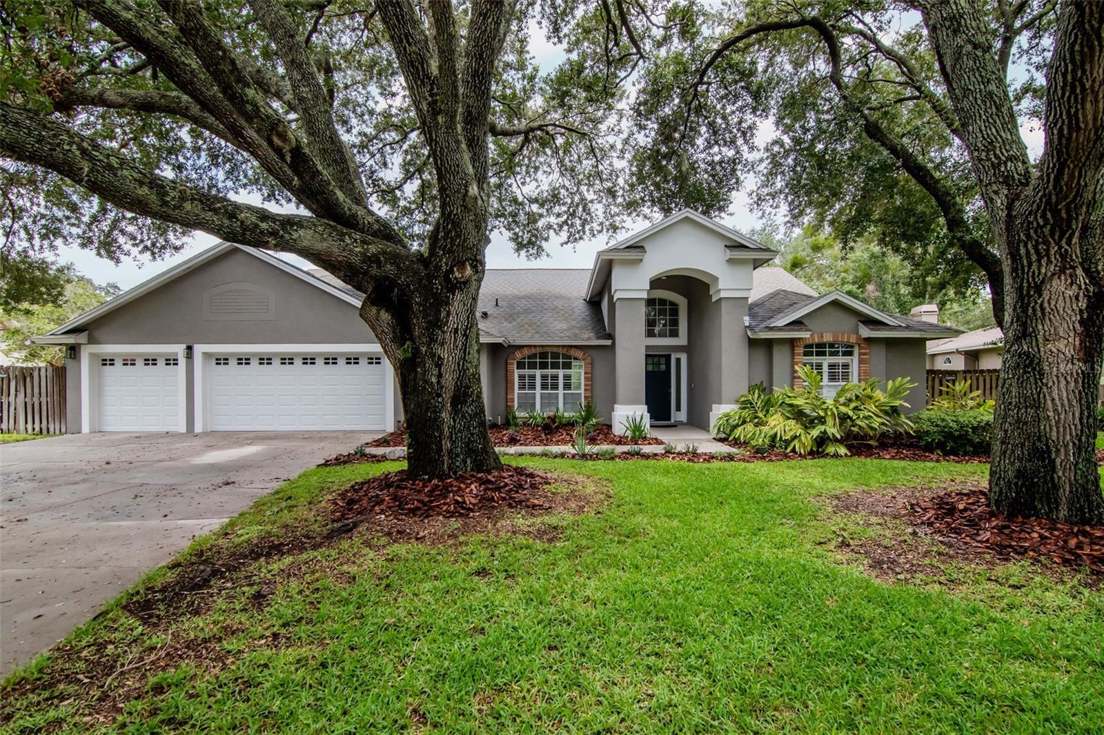 This is the Florida pool home you’ve been waiting for—where comfort meets design, and every inch feels like home. Tucked away on nearly half an acre in one of Lutz’s most exclusive guard-gated communities, this 5-bedroom, 3-bathroom stunner is all about space, style, and serenity. With a layout perfect for multi-gen living, entertaining, or just stretching out and living large, this home checks all the boxes. 
Inside, you’re greeted by soaring ceilings, wide-open spaces, and luxury vinyl plank flooring throughout the main living areas. The dining room is bright and airy, while the fully updated kitchen steals the show—think quartz countertops, sleek gray cabinetry with crown molding, a butcher-block buffet, stainless LG appliances (2024), wine fridge, statement lighting, a giant storage island, and a gorgeous pass-through to the living room, all lit by a warm skylight above. The family room brings the cozy with a wood-burning brick fireplace, rustic wood beam mantel, built-ins, and upgraded sliders that open wide to the outdoors. Whether it’s a dinner party or a Netflix night, this space is made for connection. The split-bedroom layout is designed with versatility in mind. The primary suite features vaulted ceilings, a walk-in closet, plantation shutters, pool access, and a spa-inspired en-suite with marble counters, soaking tub, tiled shower, and a dreamy chandelier. An attached bonus room adds flexibility as a home office, 5th bedroom, nursery, or zen space. Two more bedrooms + a remodeled full bath sit behind a pocket door for extra privacy, and there’s another tucked-away bedroom with its own poolside bath—ideal for teens, guests, or in-laws. A fifth bedroom near the primary is perfect for your next creative studio or office. Outside? Your own private oasis. A screened saltwater pool and spa with waterfall, covered lanai, ceiling fan, and lush fenced backyard await. The massive oak tree, gazebo, and shed (with concrete pad and hurricane straps) add both charm and function. There’s a separate side yard for pets or play—and even space to park your boat. Upgrades include a newer roof (2021), NEW AC (2024), water heater (2018), mini-split A/C in the garage (2021), epoxy floors (2022), custom shelving, and a water softener system. All in a flood zone X—no flood insurance required. Located in the beloved Manors at Crystal Lakes, this home comes with all the perks: 24/7 gated security, tennis courts, a playground, and seasonal neighborhood events that bring the whole community together. Minutes from shopping, dining, the Veterans Expressway, I-275, Tampa Premium Outlets, and more. Homes like this don’t come up often—especially not with this level of care, character, and space. Don’t sleep on it—schedule your private showing today!