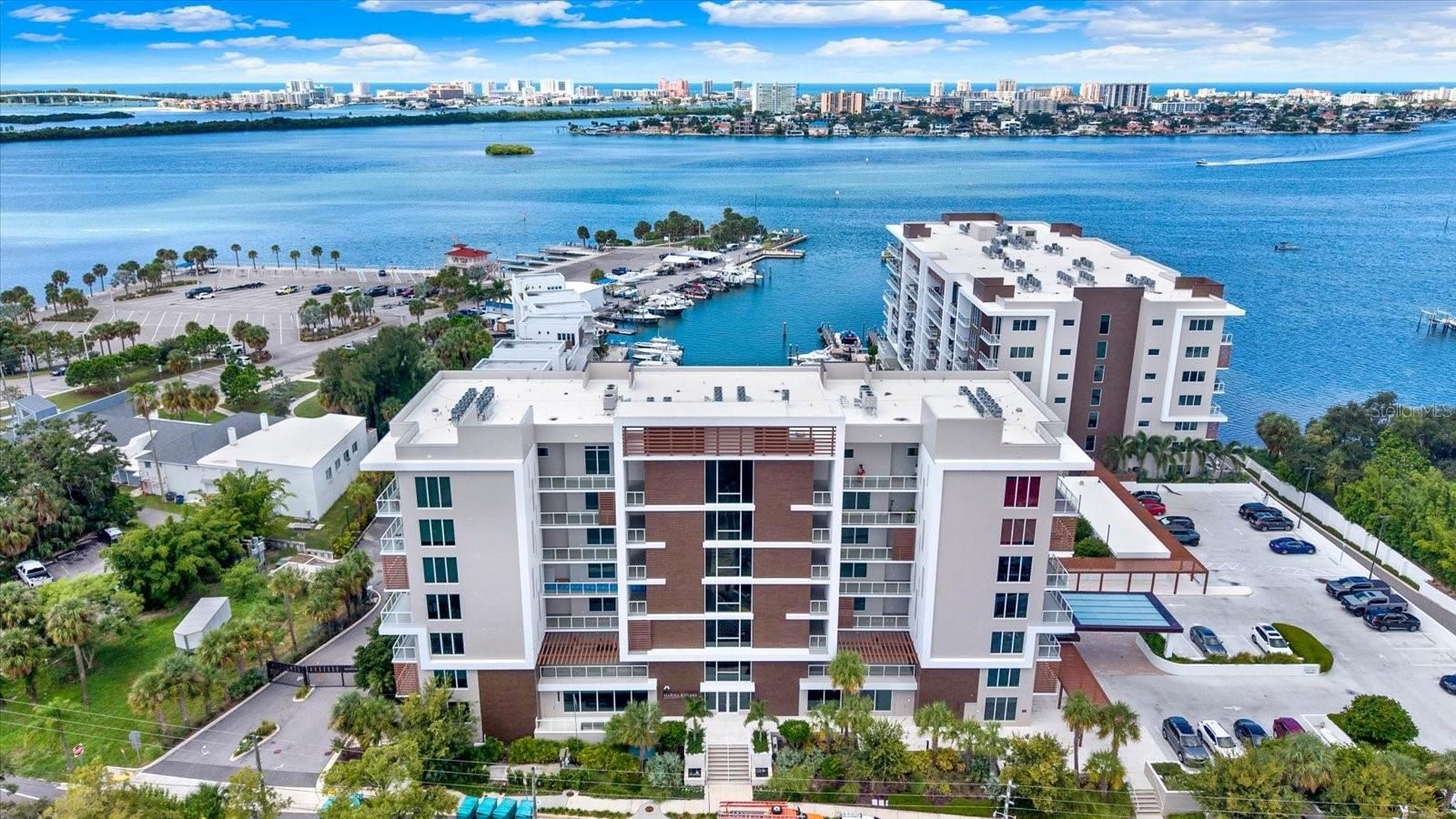 Luxury waterfront living at Marina Bay in Clearwater.** This exceptional **4th-floor corner residence** offers approximately **1,960 sq. ft., 3 bedrooms, 2 bathrooms, 2 assigned parking spaces, and three spacious private balconies**. With exposures to the **west, east, and south**, the home enjoys abundant natural light throughout the day along with beautiful views of the marina, Intracoastal Waterway, surrounding skyline, and unforgettable Florida sunsets.The expansive open-concept living and dining area is surrounded by oversized windows, creating a bright, airy atmosphere and a seamless connection to the waterfront setting. The modern kitchen features crisp light cabinetry, quartz-style countertops, stainless-steel appliances, a large center island with seating, and generous storage—perfect for everyday living and entertaining.The primary suite offers a private retreat with balcony access, a walk-in closet, and a spacious ensuite bathroom with dual vanities. Two additional generously sized bedrooms provide excellent flexibility for family, guests, or a home office. The thoughtfully designed floor plan also includes a dedicated laundry area and excellent storage.One of the highlights of this residence is its **three large balconies**, offering multiple outdoor spaces to relax, entertain, enjoy morning light, and take in western sunset views. The combination of a desirable corner position and east, south, and west exposures creates a rare sense of openness and privacy.Residents of Marina Bay enjoy resort-style amenities including a waterfront pool and spa, fitness center, sauna, elegant resident lounge, billiards and game area, outdoor entertaining spaces, and a beautiful marina setting with direct access to the Intracoastal Waterway.Conveniently located near Downtown Clearwater, Clearwater Beach, dining, shopping, entertainment, and the Gulf beaches, **900 N Osceola Ave, Unit 401** offers an exceptional opportunity to enjoy spacious, contemporary waterfront living in the heart of Clearwater.