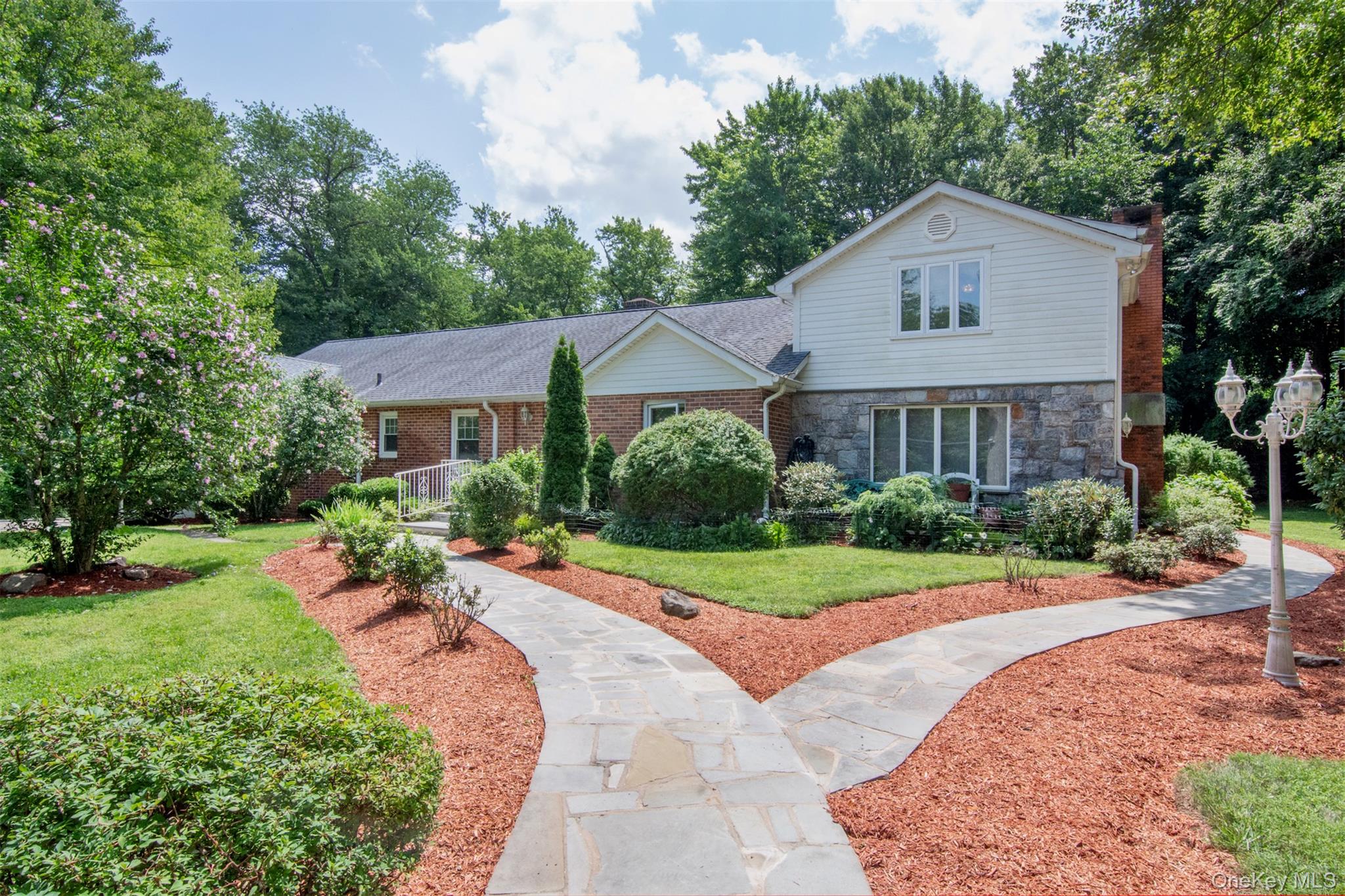 The curb appeal says it all. This spectacular home offers approximately 4200 square feet of beautifully designed living space and sits on nearly one acre of level, private, and well manicured property on a cul-de- sac. Step inside to a classic foyer featuring exquisite herringbone hardwood floors with rich mahogany inlay and a stunning sweeping staircase that serves as the home's elegant centerpiece.The thoughtfully designed main level features a walk-through kitchen that flows seamlessly into the expansive great room, creating an ideal setting for both everyday living and effortless entertaining. The spacious living and dining rooms are beautifully separated by a striking stone fireplace and enhanced by sliding glass doors that open to an expansive stone paver patio and the magnificent backyard. The first floor also offers a cozy family room with the home's original fireplace, a full bathroom conveniently located off the living room, a luxurious primary suite, and additional bedroom, a home office or optional bedroom, another full hall bathroom, abundant closet space and a convenient laundry room. Ascend the impressive staircase to the second level, where you will find the private owner's suite featuring a spacious bedroom with two walk-in closets, an additional closet, and extra storage. Adjoining the bedroom is a generously sized sitting room, perfect for a nursery, home office, or private retreat. The spa-inspired primary bathroom boasts a soaking tub, separate glass enclosed shower, dual vanities and elegant finishes. This level also includes a second oversized bedroom with a large closet, two bonus storage rooms, an additional full bathroom, and generous storage closets. In total, this exceptional  residence offers four bedrooms , and five full bathrooms. The attached one-car garage is complemented by a driveway accommodating four to five vehicles, while the circular front driveway provides parking for approximately eight additional cars. The wraparound patio and expansive level backyard with the inground  water sprinkler system, create the perfect setting for outdoor entertaining, recreation, and relaxation.. Ideally situated near parks, major highways, public transportation, schools, and shopping, this remarkable property combines timeless elegance, generous living space, and an unbeatable location.