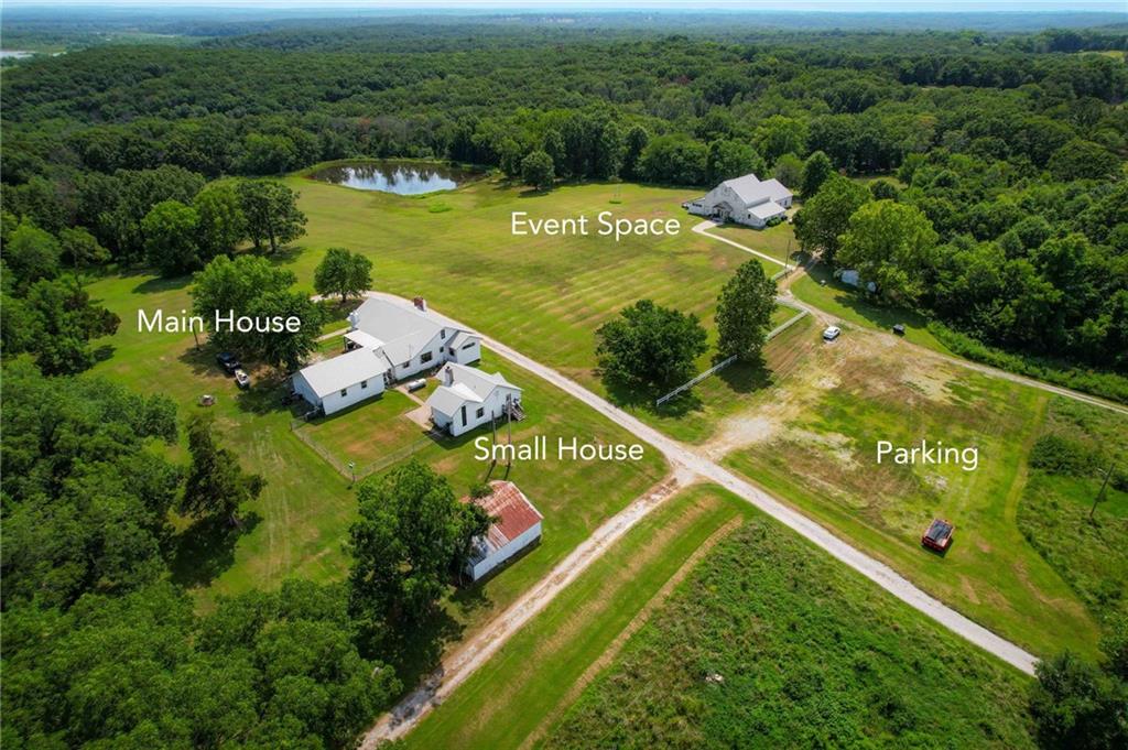 Welcome to Top of the World, a truly one-of-a-kind 52+ acre property overlooking the Osage River and the town of Osceola. With breathtaking views, multiple residences, an established event venue, ponds, outbuildings and abundant acreage, this unique property offers endless possibilities for a private estate, family compound, retreat, event destination or income-producing property.The estate features four separate living spaces. The main residence offers 3 bedrooms, 2 baths and an impressive Great Room designed for gathering and entertaining. A second home located just behind the main residence features 1 bedroom, 1 bath and the property's original ice house. Two additional cabins provide even more accommodations, including a 2-bedroom, 1-bath cabin built in 2017 and another 2-bedroom, 1-bath cabin overlooking the pond with a partially covered wraparound deck.At the heart of the property is a versatile event venue equipped with a full kitchen, laundry facilities, storage, separate men's and women's restrooms, dressing areas and expansive covered outdoor entertaining space. A large patio and deck overlook the stocked pond, creating an incredible setting for weddings, retreats, reunions, corporate gatherings and private events.The property itself is just as impressive. An artesian well continually supplies fresh water to the pond, while the combination of open acreage and wooded areas creates a beautiful and private setting. Multiple garages, barns and outbuildings provide ample room for equipment, storage, hobbies or future uses.Whether you're searching for a remarkable private estate, multi-generational property, event venue, retreat destination, short-term rental opportunity or a property where you can live, work and entertain all in one location, Top of the World offers a combination of improvements, acreage and views that is nearly impossible to duplicate.This isn't simply a home on acreage—it's an opportunity to create a destination.