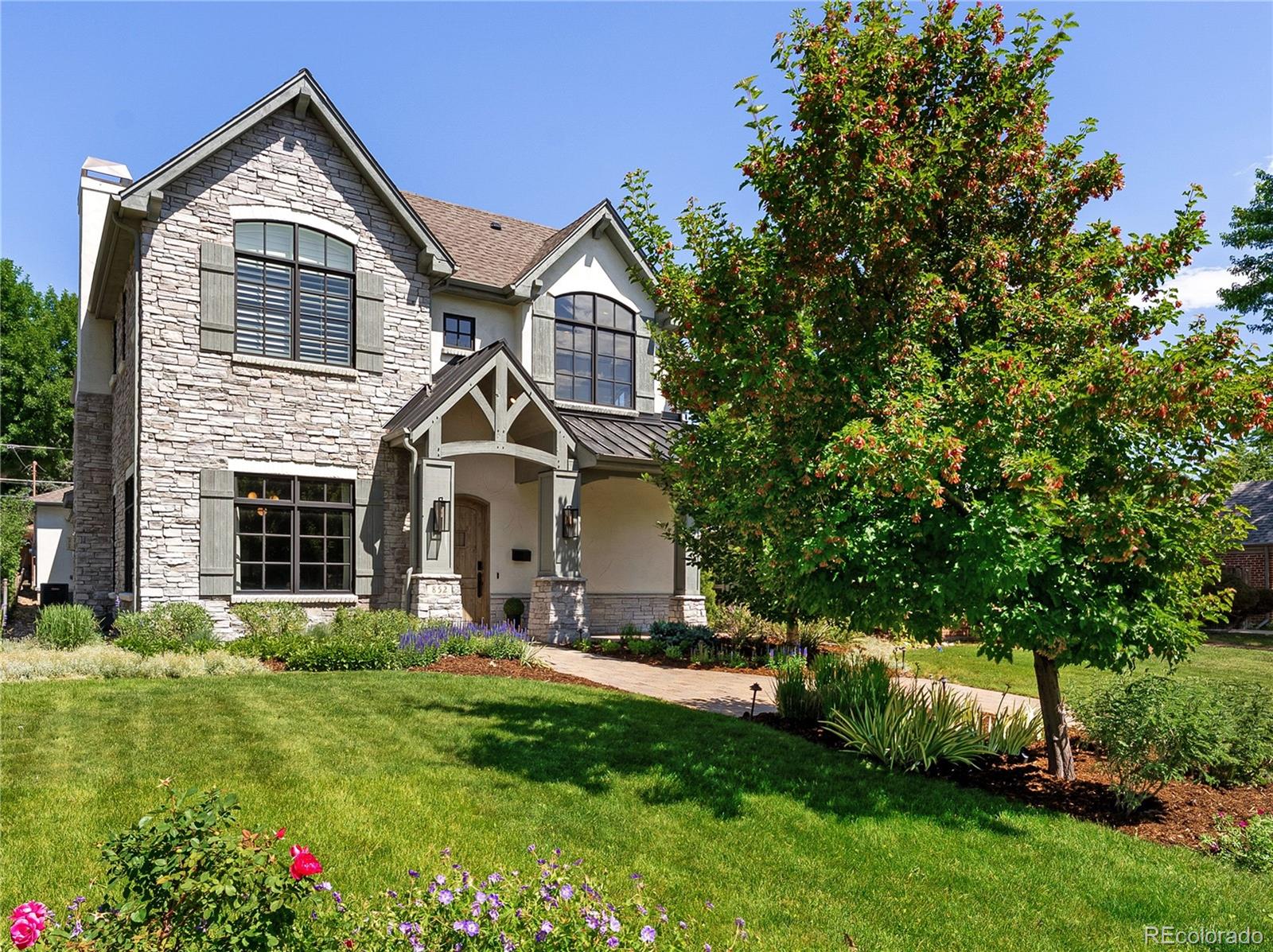 Every inch of this stunning Montclair home has been thoughtfully curated and beautifully finished. Fully remodeled in 2021, it blends timeless architecture with up-to-the-minute design. From the moment you enter the dramatic two-story foyer, the level of detail is undeniable—arched doorways, hand-troweled walls, designer lighting and refreshed trim set the tone for a home that’s both sophisticated and welcoming. Striking alder wood ceiling beams, custom wood flooring, wall paper and architectural built-ins add warmth and personality throughout. The gourmet kitchen features double-stacked cabinetry, a Bosch refrigerator and dishwasher, walk-in pantry, and butler’s pantry that connects to the elegant dining room with tray ceiling and fireplace. A stylish main-floor study with custom built-ins and stunning French doors offers the perfect work-from-home setup, while an incredible mudroom adds function and storage off the attached 2-car garage.  Upstairs, the vaulted primary suite exudes quiet sophistication with a vaulted and beamed ceiling, fireplace, hardwood floors, plantation shutters, and a beautifully designed bathroom—complete with freestanding tub, paned-glass shower enclosure, and dual vanities. Two additional bedrooms, an updated full bath, and a laundry room with utility sink complete the upper level. The finished basement is equally impressive with a custom theater area, showpiece wet bar with waterfall quartz counter, two beverage refrigerators, dishwasher, and built-ins and yet another fireplace. You’ll also find a spacious bedroom, oversized spa-like bath, craft room, and a clever hidden room tucked behind a bookshelf. 
Additional highlights include Sonos speakers throughout, two tankless Navien water heaters, and owned solar panels for excellent energy savings. Outside you will find a wonderful oasis with a paver patio, 5th fireplace, custom waterfall and deluxe hot tub. Located just one block from lovely Kittredge Park!