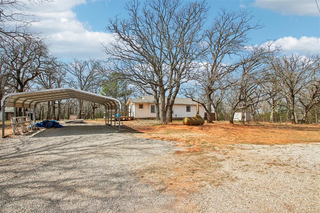 Opportunity awaits on this acreage nestled in SE Norman. 2 bedroom and 1 full bath and a carport large enough for 2. All the rooms are spacious in the home and all the flooring is either real hardwood floors or laminate. The kitchen offers a gas oven/range and plentiful cabinets. 2.55 acres treed and fenced, with multiple outbuildings, raised gardens, and a large in-ground storm shelter. New roof this year!