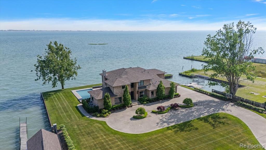 The epitome of luxury waterfront living is this stunning 4 bedroom custom-built and designed home ideally situated on 210’ of frontage on stunning Lake St. Clair in highly sought-after Anchor Bay. With nearly 5,000 square feet of exquisitely finished living space, this 2017 built masterpiece blends elegance, amenities, comfort, and thoughtful design throughout.Enjoy your own 400sqft protected boat harbor that can comfortably house 3 boats and multiple jet skis. Take in breathtaking lake views from the custom in-ground pool and hot tub, perfectly situated for both relaxation and entertaining. Inside, everything is custom, from the gourmet kitchen with a large island and high-end appliances, to the stylish wet bar with beverage coolers.The spacious living room features a gas fireplace and is filled with natural light from walls of windows. Step out onto the expansive second-floor balcony that wraps around the home to take in panoramic views. The stunning first floor primary suite offers a spa-like bath with a vanity area and a large walk-in closet. French doors lead to the pool deck and outdoor shower. Upstairs, you’ll find two additional bedroom suites each with its own full bath, plus a bonus room perfect for a home office, playroom, or media space. The beautifully designed outdoor area off the kitchen is ideal for al fresco dining or unwinding by the water. A 3-car attached garage completes this incredible package.This is luxury waterfront living at its absolute finest. Refined, spacious, and ready to enjoy!