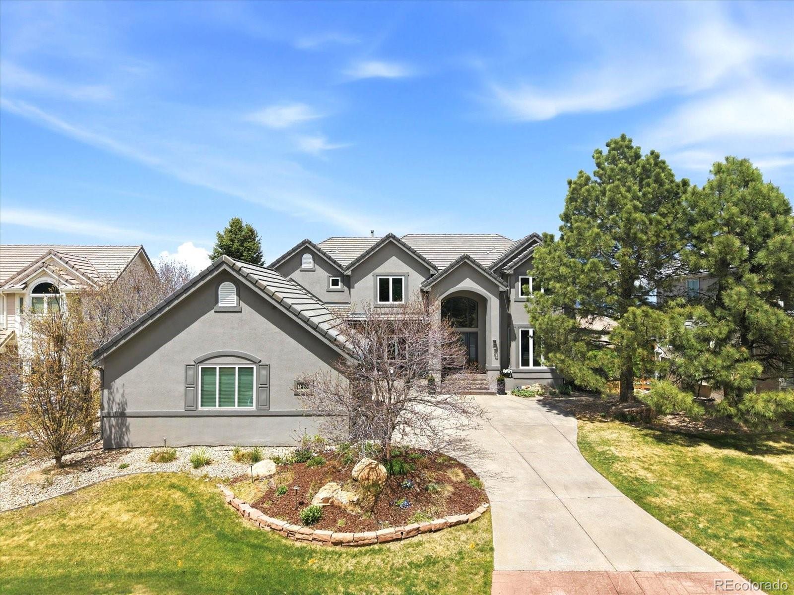 Perched steps from the iconic Historic Mansion and its 50 acres of open space and trails, this exceptional Highlands Ranch residence delivers the panoramic mountain and downtown Denver views you moved to Colorado for — from virtually every room in the house. Five bedrooms, four-and-a-half baths, and just under 5,300 finished square feet across three thoughtfully designed levels.The heart of the home is a chef's kitchen with a leathered quartz island, stainless appliances, and sweeping Rocky Mountain and city skyline views. A private study with French doors and its own deck is the rare work-from-home space that actually inspires. The coffered-ceiling dining room and generous family room round out a main level built for both everyday living and effortless entertaining.Upstairs, the vaulted primary suite offers a true retreat — French doors frame the mountain and Denver views, while the five-piece bath features a freestanding soaking tub, dual closets, and heated floors. Three additional bedrooms are well-proportioned, with two offering those same signature views, and flexible bath configurations including an en suite and a Jack & Jill.The walkout basement is where the fun lives:a tiered home theatre, a sprawling great room with wet bar, wine cooler, and mini fridge, a fifth bedroom currently used as a gym, and a fully remodeled bath. The oversized garage handles everything Colorado life demands. Nearly 70 miles of Highlands Ranch trails, four community rec centers, and quick C-470 access complete the picture.
