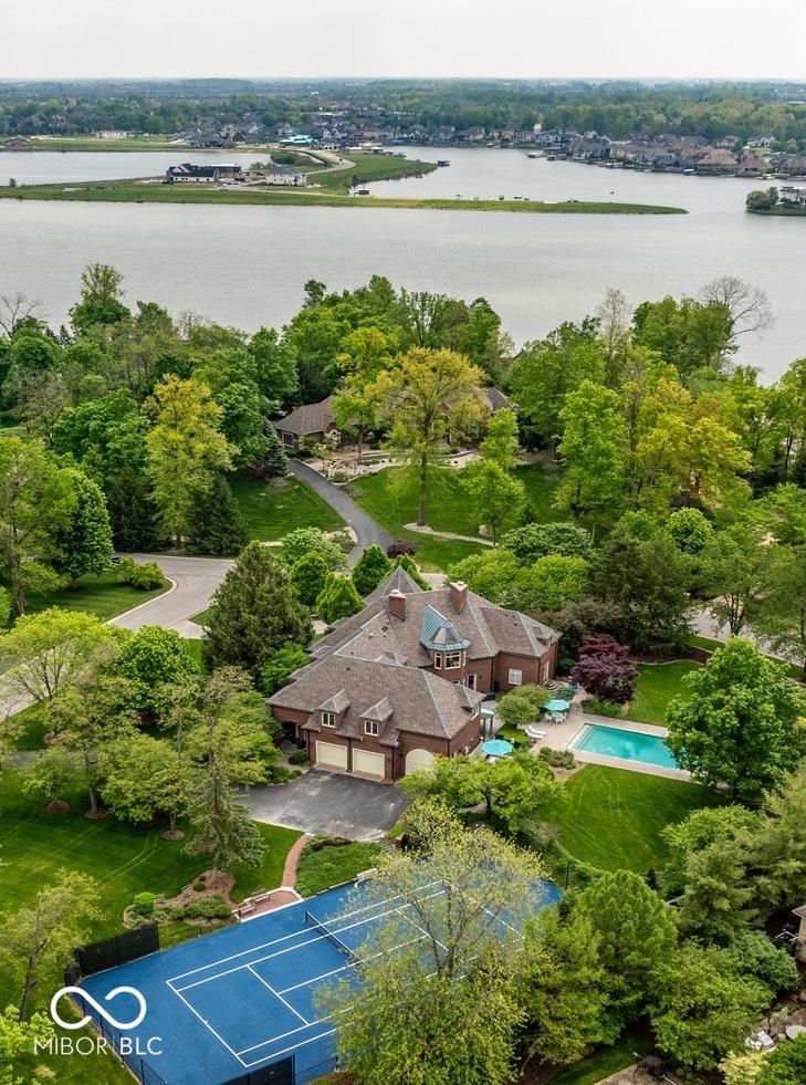 10,000 square feet of grand, custom living space. The privacy of a solid 6-foot brick wall enclosing a sprawling two-acre lot. The safety and comfort of a gated secure neighborhood. Elite peace of mind for the entire family and your guests inside the exclusive Breakwater community. Resort Amenities: Park like setting, Private gunite pool, private tennis/sport court, home gym with a steam shower. Irreplaceable Craftsmanship: Intricate trim carpentry, custom cabinetry and structural details no modern custom builder would match near this price point. Outdoor Living: Expansive porch spaces built for entertaining. This Home comes with the first boat slip in the neighborhood marina and a shared lakeside patio, convenience to premium Geist Lake living and recreation. This home offers new owners a remarkable lifestyle in today's luxury market.
