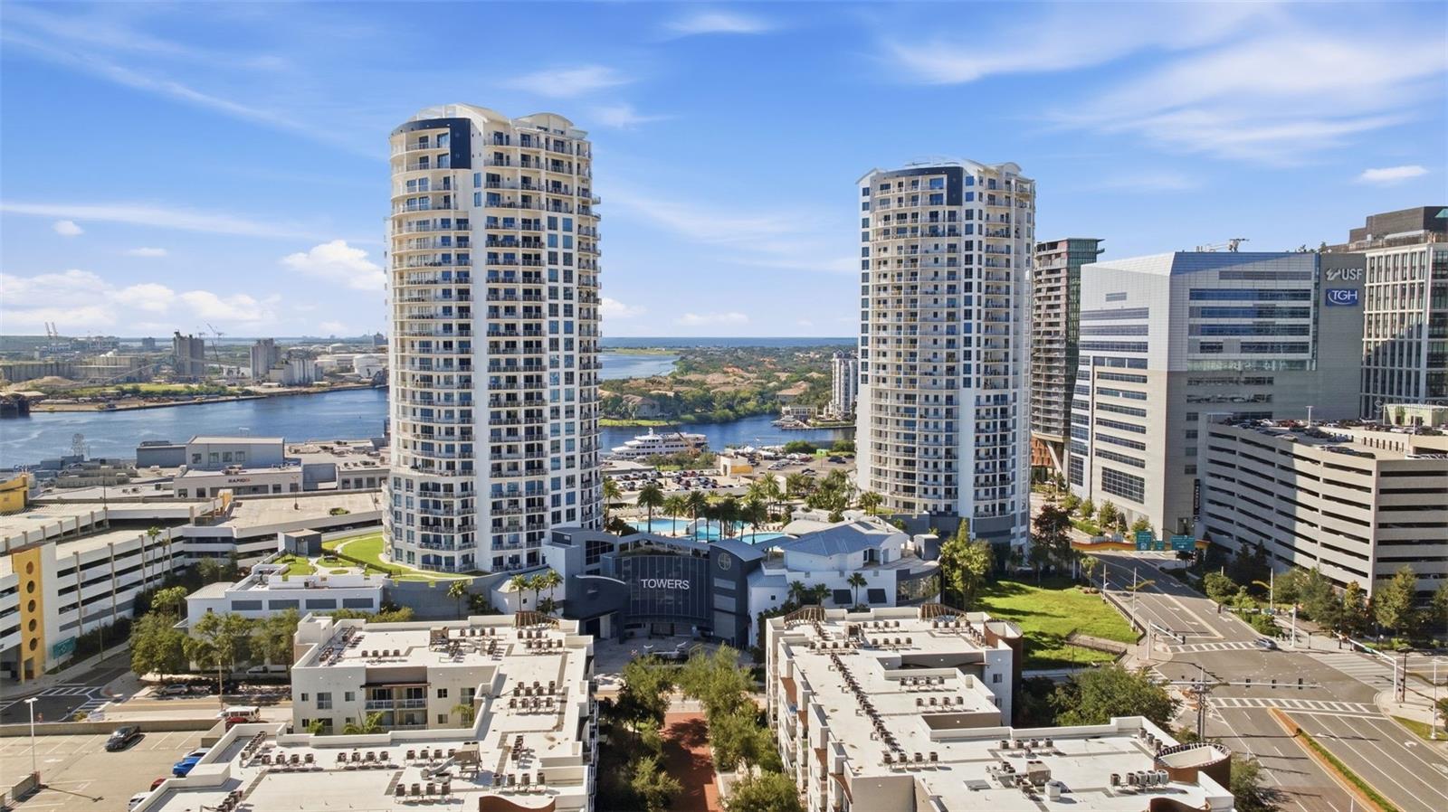 Welcome to elevated urban living 20 floors above the heart of Tampa’s highly sought-after Channel District. Located in The Towers of Channelside, this immaculately maintained 2-bedroom (With custom closets), 2.5-bath condominium offers 1,269 square feet of thoughtfully designed living space, incredible natural light, and sweeping views that showcase Tampa from an entirely new perspective.From the moment you step inside, the floor-to-ceiling windows (with remote-controlled shades) draw you toward the spectacular scenery beyond. The living space is sun-drenched throughout the day, creating a bright and inviting atmosphere while showcasing panoramic views of Tampa Bay, Harbor Island, and the surrounding cityscape. Step onto the expansive wraparound porch with coveted southern-facing views, the perfect place to enjoy your morning coffee, entertain guests, or watch cruise ships make their way in and out of the Port of Tampa. Inside, the home has been exceptionally cared for and is truly move-in ready. The kitchen features beautiful granite countertops, stainless steel appliances, and real wood cabinetry, creating a timeless combination of style and functionality. The open floor plan provides comfortable spaces for both everyday living and entertaining, while the split-bedroom layout offers privacy and flexibility for a full-time residence, downtown retreat, second home, or investment opportunity. The Towers of Channelside delivers an impressive collection of amenities designed to make everyday life feel effortless. Residents enjoy a beautiful pool and spa, fitness center, secure entry, concierge services, on-site management, and a large clubhouse with an expansive outdoor hosting and entertaining space—perfect for gatherings with friends and family. For pet owners, the amenities are especially hard to beat. The fifth floor features a gated outdoor dog park, green space, and paved walking path, making The Towers of Channelside arguably one of the most pet-friendly high-rise communities in Channelside and Downtown Tampa. Your four-legged companions have their own dedicated outdoor space without ever leaving the building. And perhaps one of the greatest advantages of this location: you don't need a car to enjoy downtown Tampa. Walk to Lightning games and concerts at Benchmark International Arena, explore Water Street Tampa and Sparkman Wharf, stroll the Tampa Riverwalk, visit the Florida Aquarium, grab dinner at one of the many nearby restaurants, or simply enjoy everything the Channel District and Downtown Tampa have to offer. Publix is also nearby for everyday convenience, while the TECO Line Streetcar provides easy access throughout the urban core and to historic Ybor City. Additional conveniences include a private storage room and two assigned parking spaces located underneath the building, giving you the best of both worlds: the freedom to live a walkable downtown lifestyle while still having secure parking when you need it.With its 20th-floor elevation, floor-to-ceiling windows, abundant sunshine, wraparound porch, southern-facing views, beautifully appointed kitchen, immaculate condition, extensive amenities, dedicated pet spaces, large clubhouse and outdoor entertaining area, storage, and two assigned parking spaces, Unit 2005 is a rare opportunity to experience the best of high-rise living in the heart of Tampa. Come experience the views, the lifestyle, and the convenience for yourself—this is downtown living at its most effortless