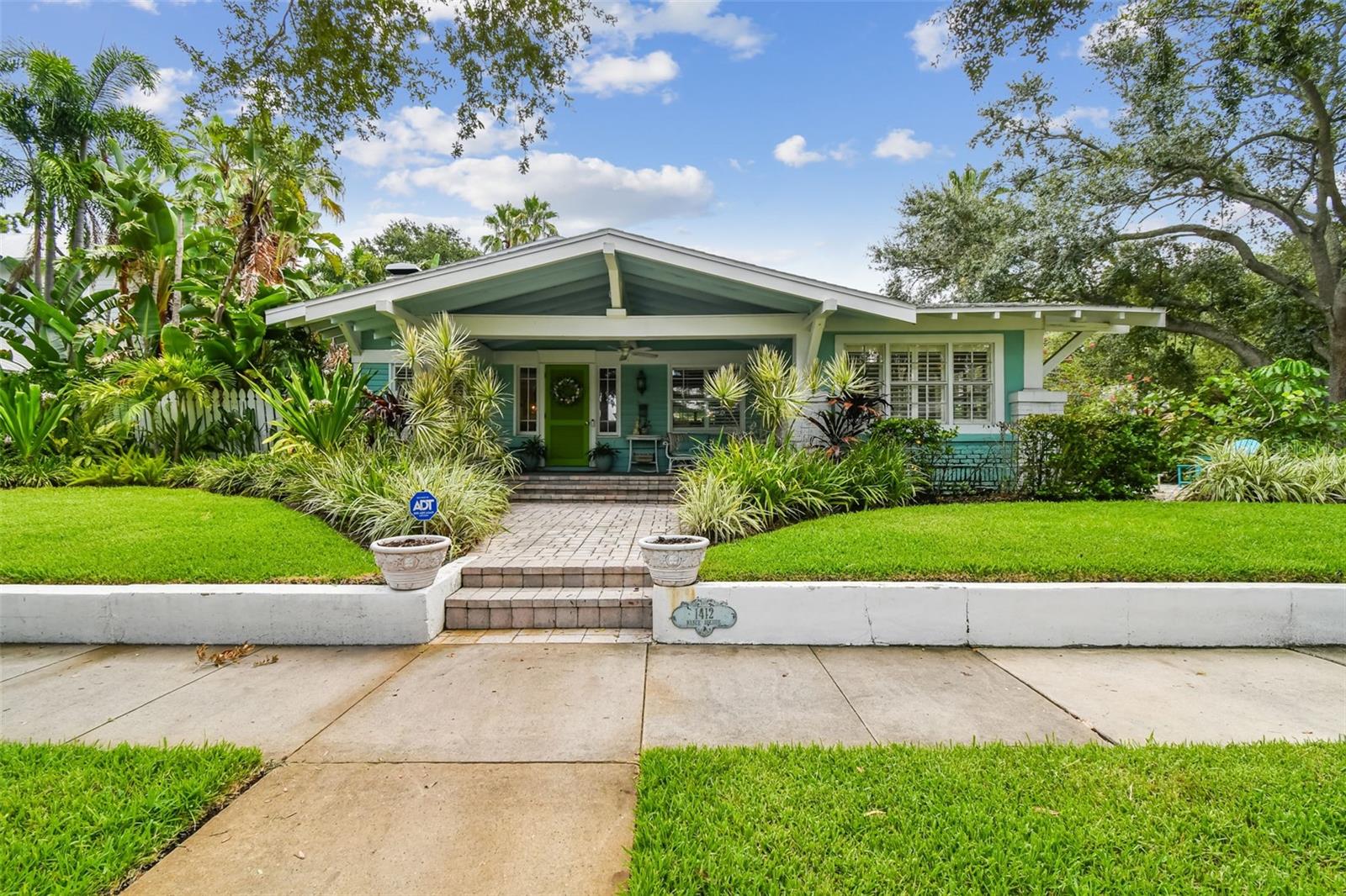 This timeless 1914 Hyde Park residence offers 2,276 square feet of character-rich living space on a rare lot and a half, perched approximately 20 feet above sea level. The property presents a unique opportunity to enjoy a  smaller-scale home in Hyde Park or take advantage of the generous lot to add a garage or guest house.Inside, hardwood floors, ornate crown molding, custom shutters, and high coffered ceilings create a sense of grandeur throughout. The formal living room showcases built-in bookshelves and a wood-burning fireplace, while the formal dining room features beveled baseboards, a coffered ceiling, and bay windows overlooking the pool. A sunroom overlooking the side yard brings abundant natural light into the home. The kitchen is a chef’s delight, complete with dual ceiling fans, a center island with bar seating, GE Profile 5-burner natural gas cooktop with vented hood, double built-in ovens, and a cozy corner dining spot. A secondary sitting area with French doors opens to the patio, while a large laundry room adds everyday convenience. The primary suite offers a walk-in closet and a spacious sitting/dressing room that can easily be converted into an ensuite. Bedroom two highlights heart-of-pine wood floors, a custom-built bookshelf with desk, and closet units framing large double-hung windows. Outdoors, the tropical backyard is a private retreat with a resurfaced 40x15 heated pool, outdoor shower, and lush landscaping maintained by a 6-zone reclaimed water sprinkler system. A brick-paved driveway and both side and rear parking pads with space for three vehicles provide ample parking options. Additional features include underground utilities (electric, phone, fiber optic), private paver alley, Roof (2016), AC (2018).This property is a rare find—original features, elegant touches, and room to expand—all in one. Whether you’re drawn to its historic charm or envisioning future possibilities, this home offers a truly unique opportunity