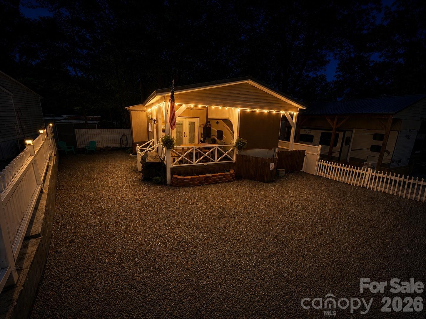 Welcome to this beautifully maintained and well appointed 2016 Keystone Cougar 36' featuring 2 slides-outs and a spacious full addition. Relax and entertain on the covered front porch complete with custom bar, cozy seating area  and a small beverage refrigerator. Step inside to a warm and inviting living space featuring stylish decor, bead board ceiling and wide plank laminate flooring throughout. The couch makes a queen size bed. The open concept layout flows seamlessly from the living room into the kitchen, highlighted by a large center island and ample workspace. The dining area is currently set up a home office and includes a charming fireplace for added comfort.The bedroom offers a queen size bed, while the oversized bathroom includes a washer and dryer that will remain with the home. Additional insulation has been added to the walls and ceiling for improved efficiency and comfort. Recent updates and improvements include: New GE 18 gallon electric water heater (installed 2/26), Smart Capabilities: WiFi Door lock and thermostat. HVAC fully serviced. Replaced the air handler control board and outside unit defrost board (12/25). Complete PEX Re-plumbing with the camper hot water connection. Fully operational camper HVAC system. Most furnishings and appliances will remain, excluding the safe, green kitchen lamp and bathroom picture. This move in ready property offers comfort, convenience and charm!!  Come and see if this is your "Happy Place" here in the park.All buyers must be with realtor to gain access to the community.